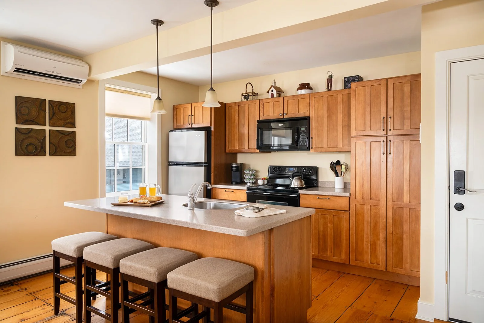 Full kitchen in Orion's Retreat Stowe VT with island seating, wood cabinerty and open layout for gathering 