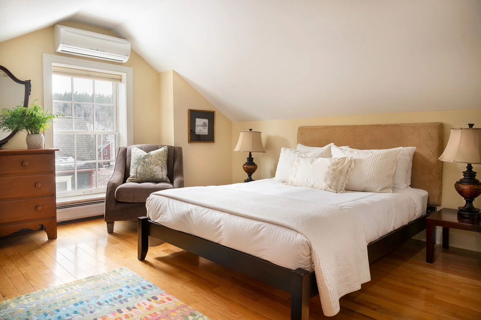 West queen bedroom in Orion's Retreat Stowe Vermonth with sloped ceiling, hardwood floors and cozy seating corner