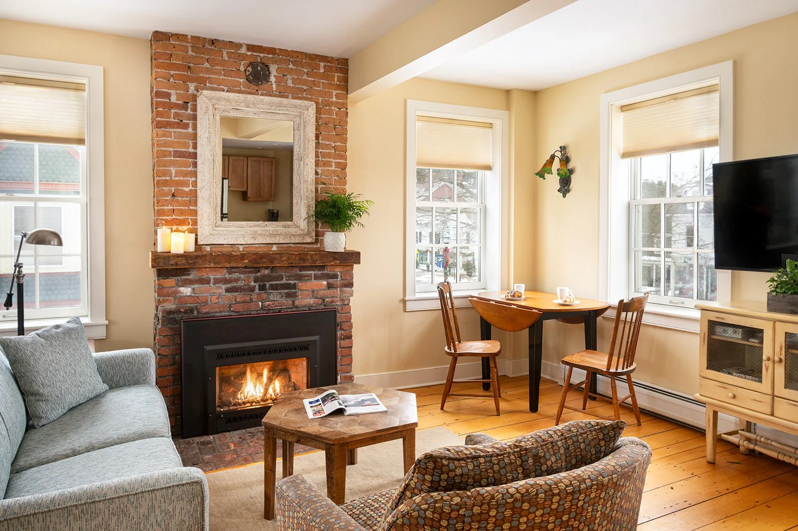Gas fireplace and dining nook in Sarah's suite with views of historic Stowe Village and historic brick accents