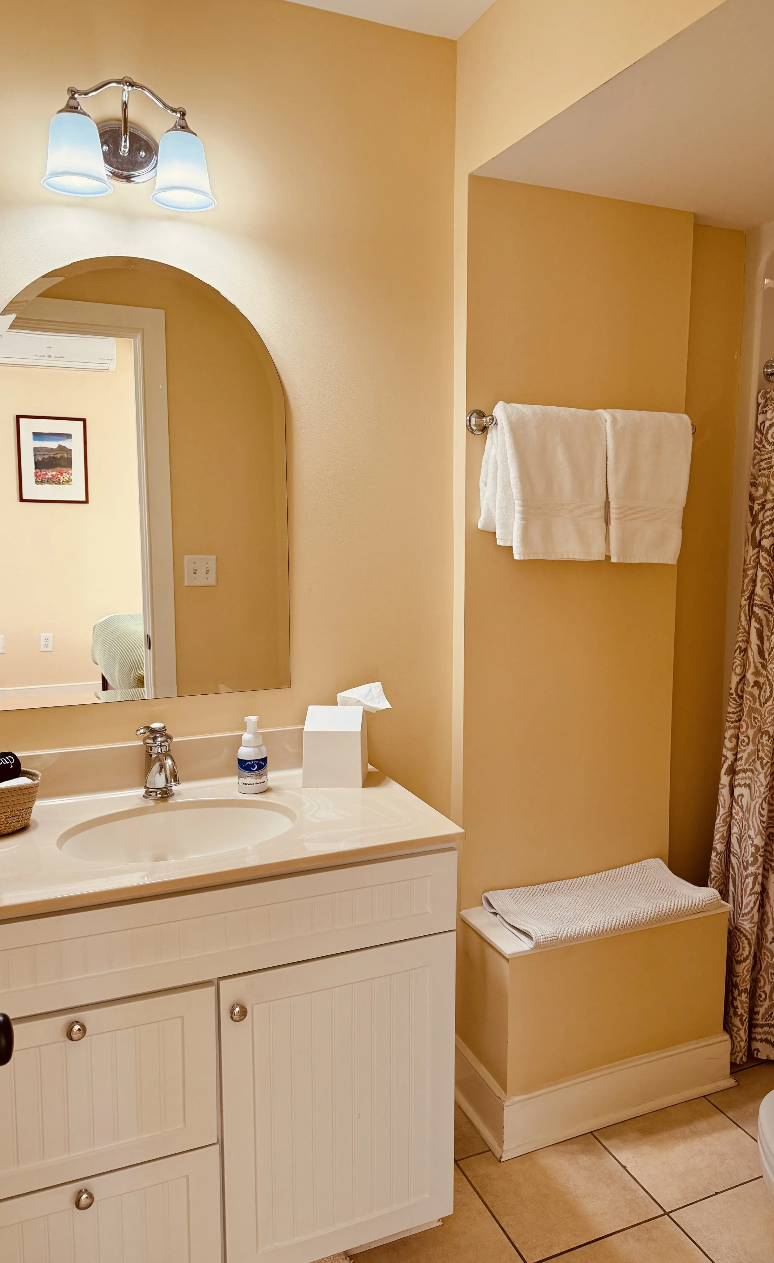 Bathroom in Sarah's suite featuring clean vanity, soft lighting and simple functional design