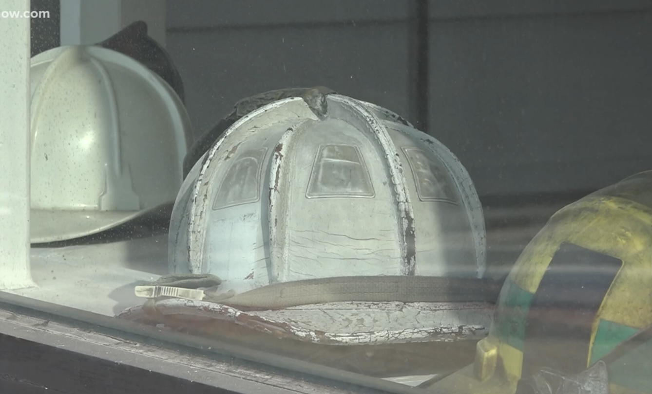 A collection of safety helmets, including white, yellow, and a metallic one.