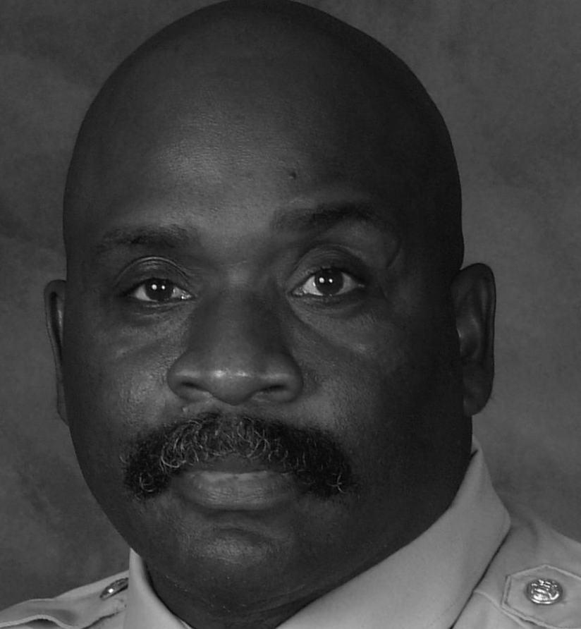 Black and white portrait of a man in a uniform with a serious expression.