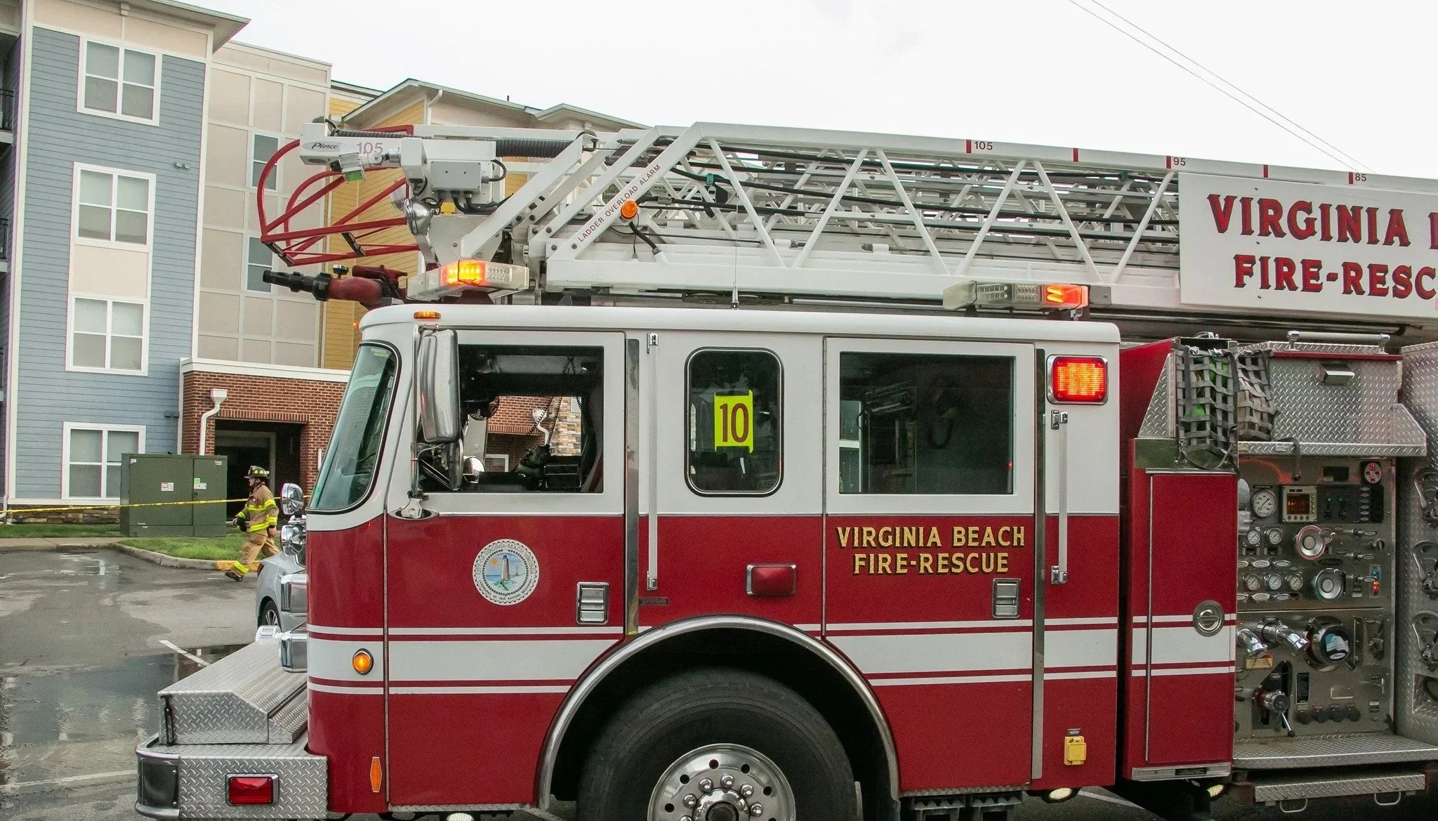 A Virginia Beach fire rescue fire truck parked on a street with multi-story buildings in the background. 