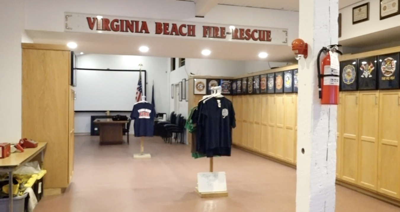 The interior of the Virginia Beach Fire Rescue station with clothing displays and framed patches on the walls.