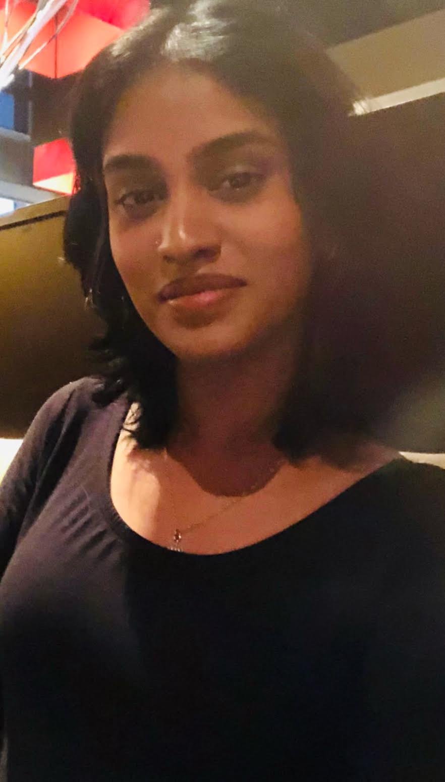 Illustration of a green bird sitting in a nest made of twigs with green leaves, on a white background.