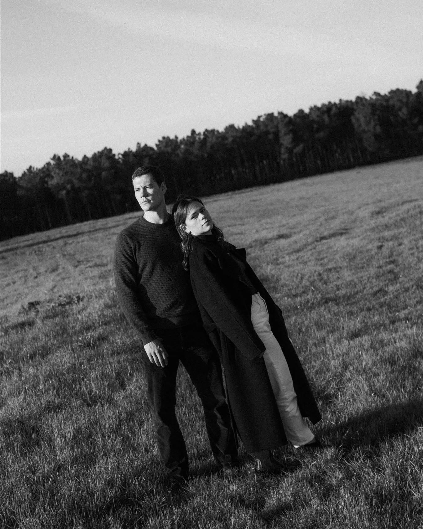 Couple standing together in an open field during a couple session in Portugal captured in black and white
