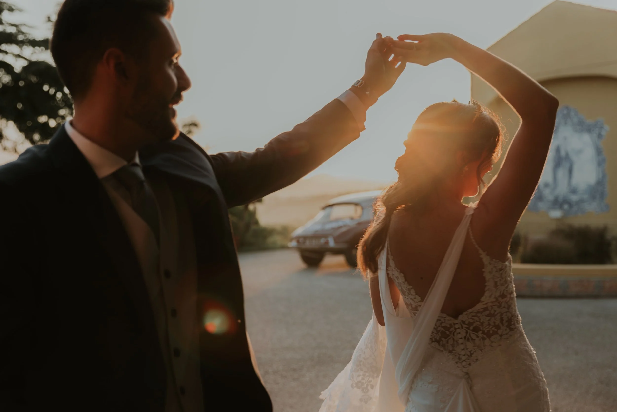 Bride and groom dancing at sunset, with golden sunlight shining between them in a joyful and intimate wedding moment, captured by Carlos Mendes Photography.