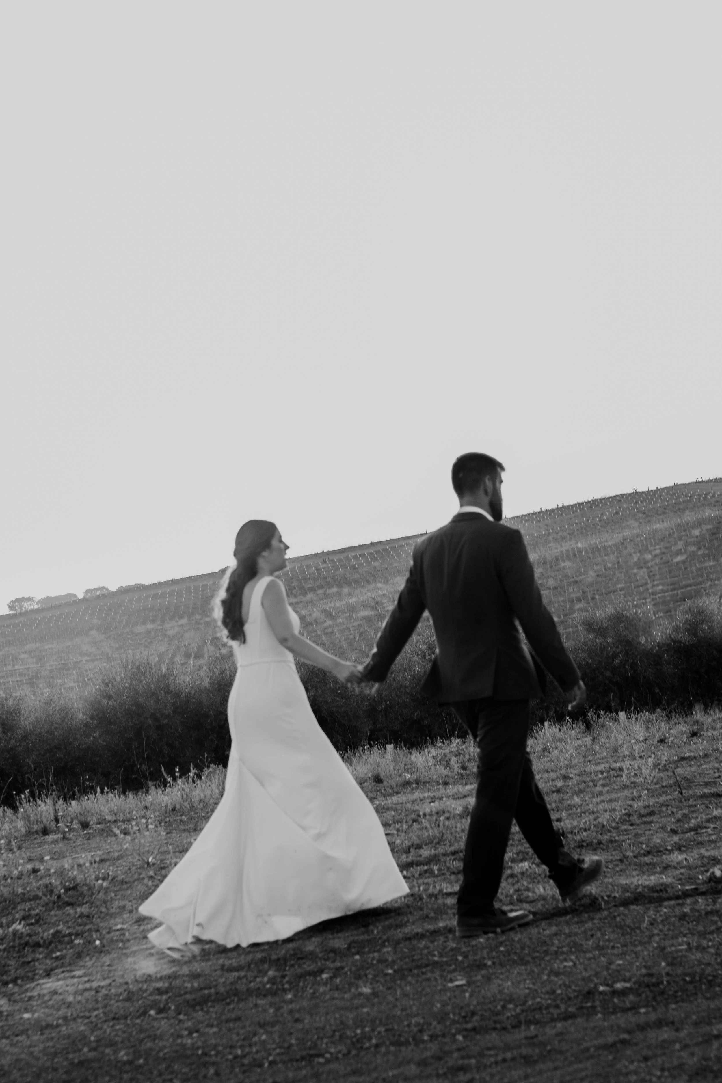 Bride and groom walking together during a wedding in Portugal captured in black and white