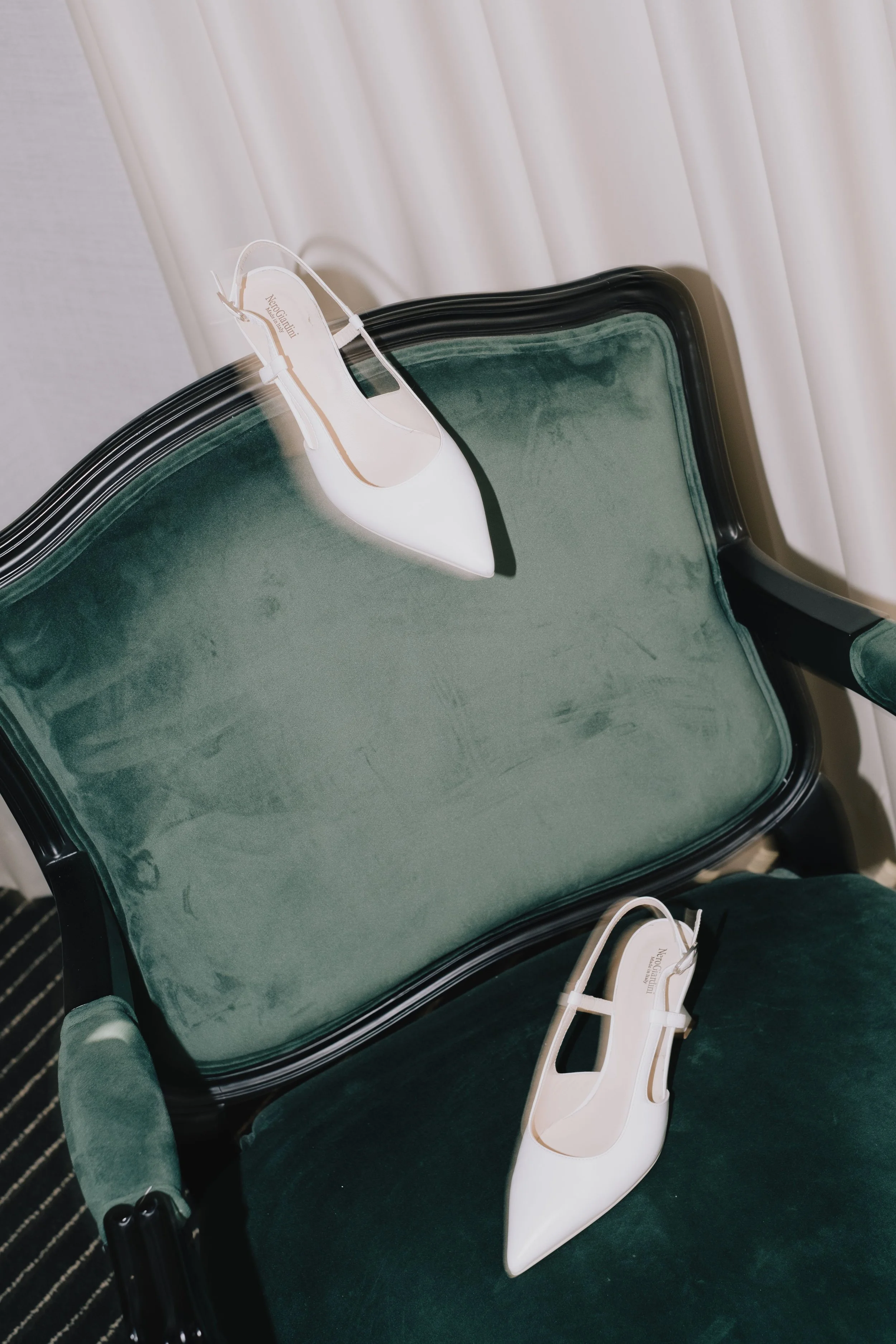 Elegant bridal shoes placed on a chair in a refined editorial wedding detail setting