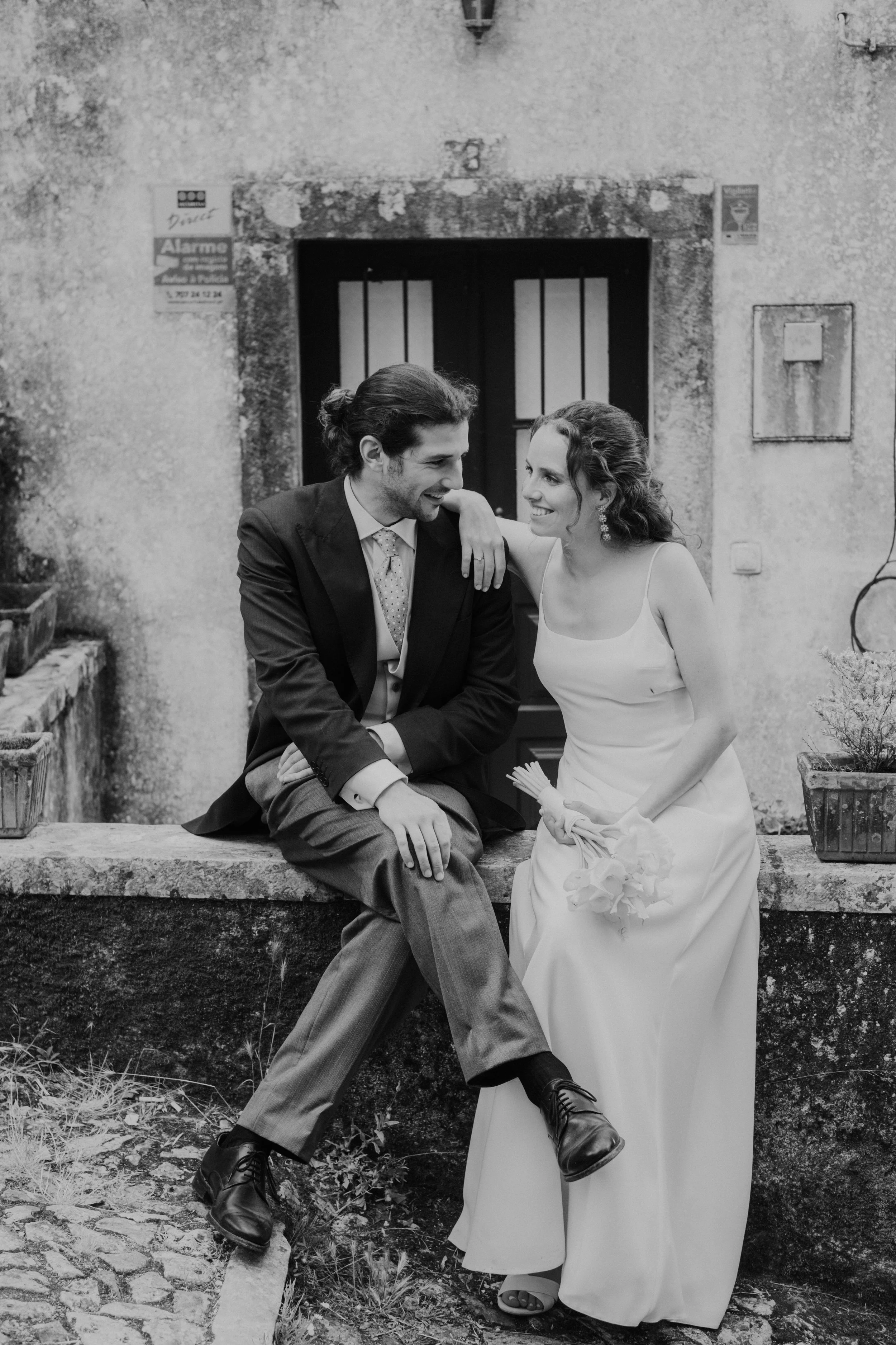Bride and groom sitting together during an intimate outdoor wedding in Portugal