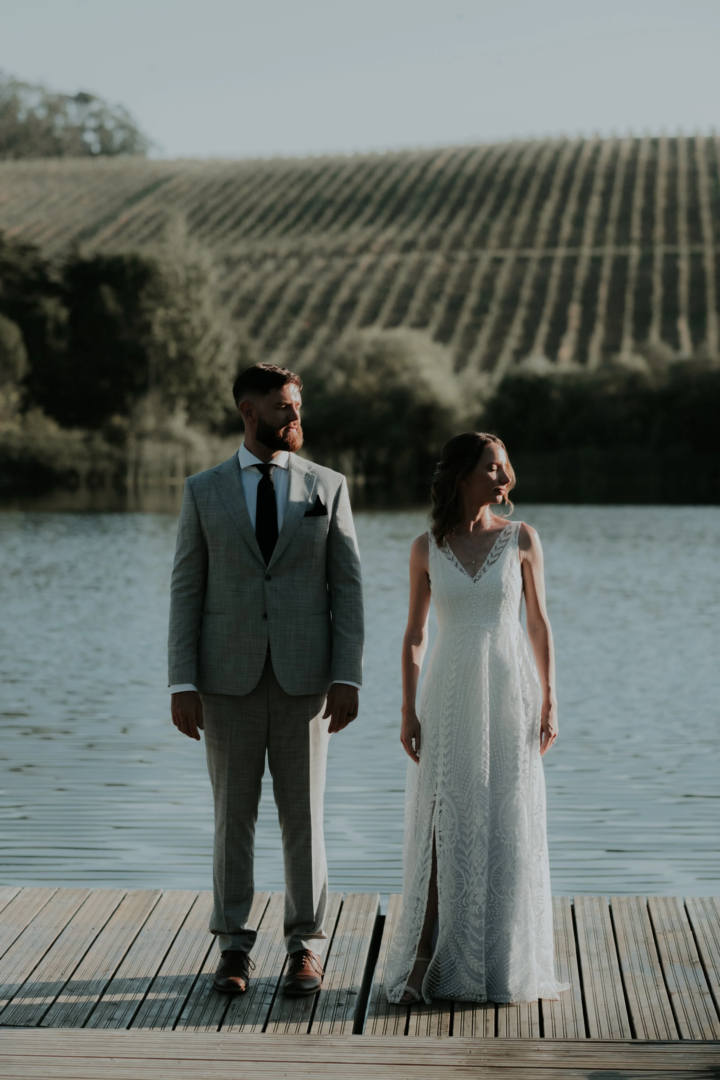 Bride and groom standing together by the water during a destination wedding in a natural setting