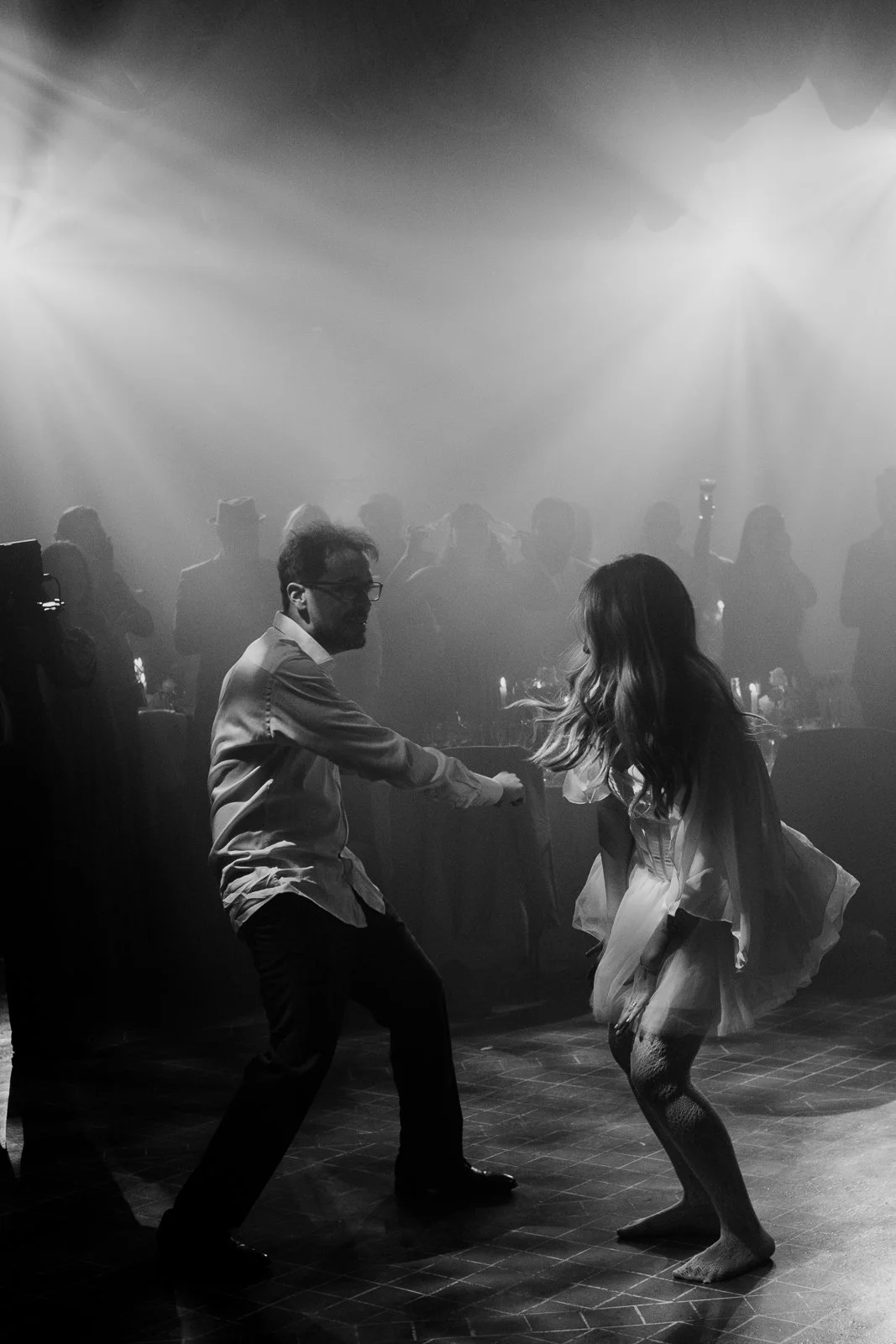 Bride and groom dancing together on the dance floor during a wedding celebration at night
