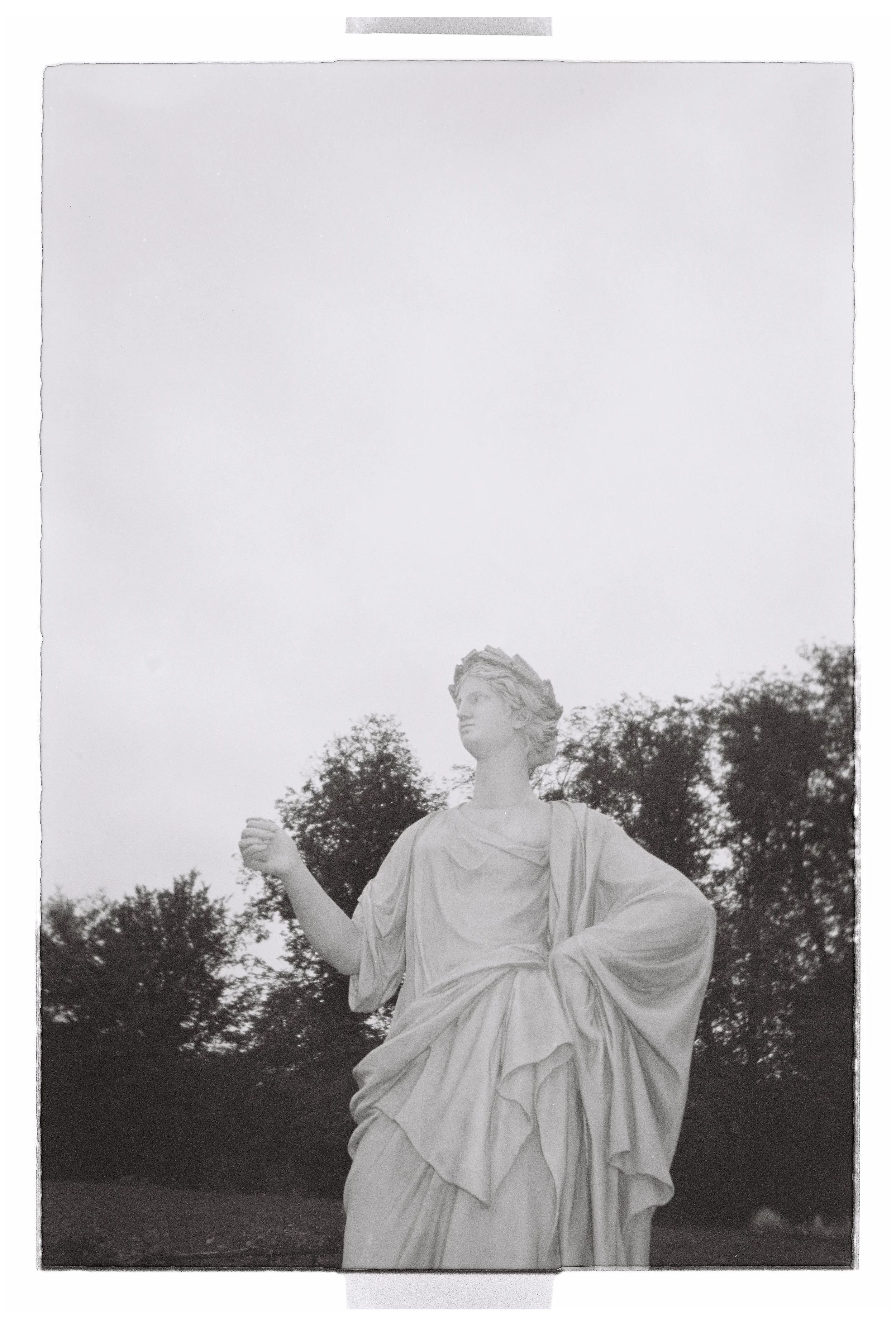 Classical statue captured in an artistic black and white composition with an editorial aesthetic
