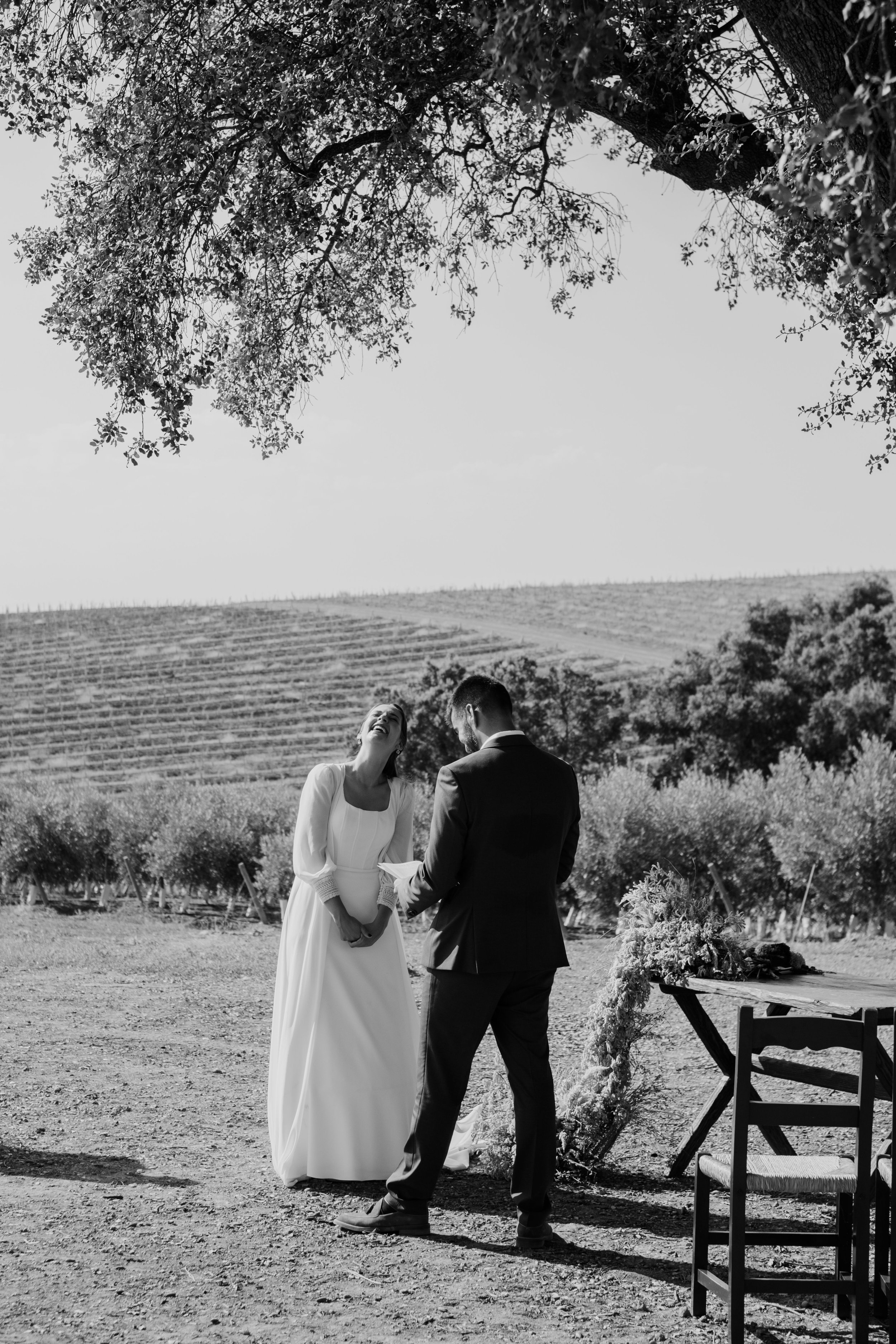Bride and groom standing together during an outdoor wedding ceremony in Portugal captured in black and white