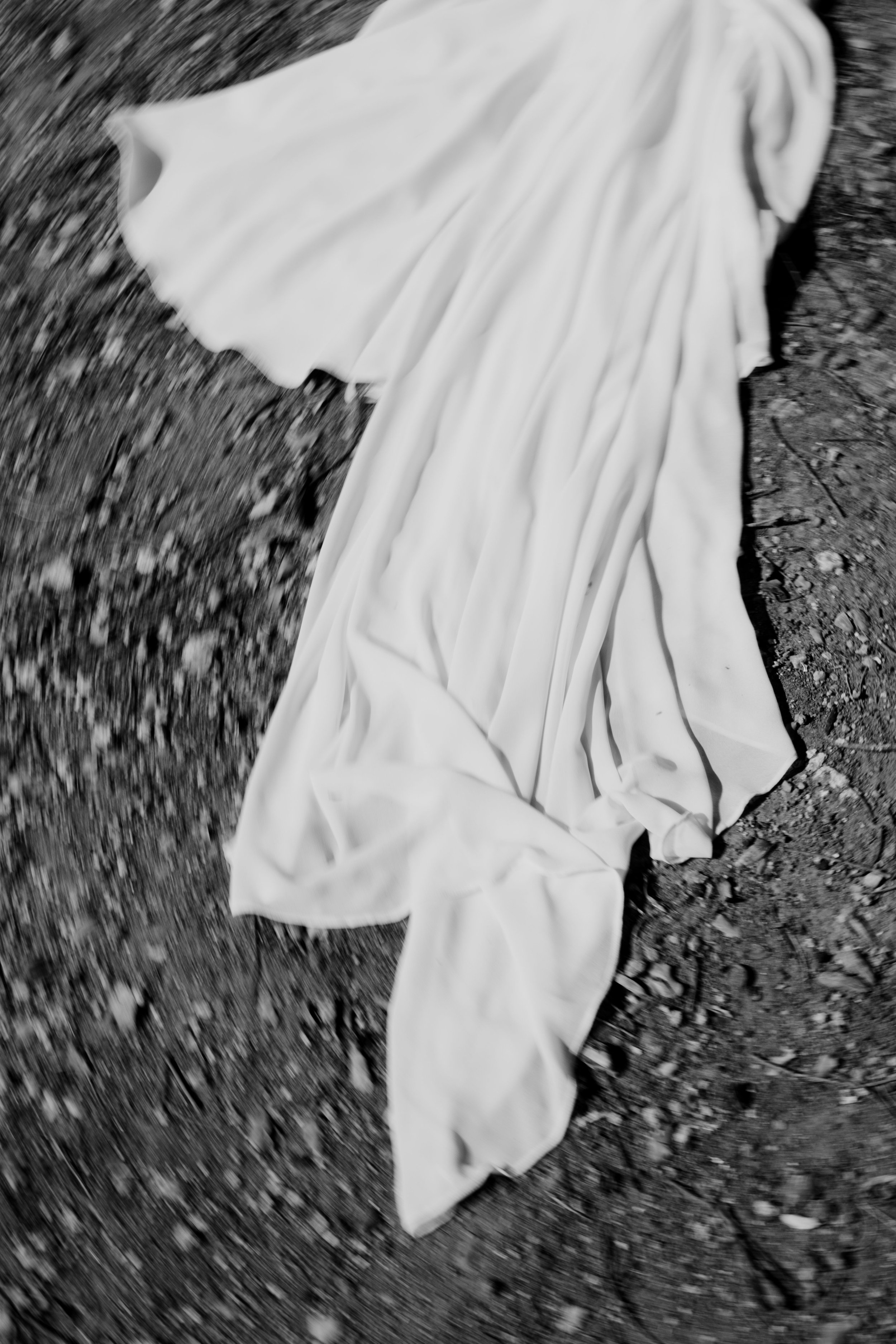 Flowing wedding dress captured in motion in an artistic black and white composition