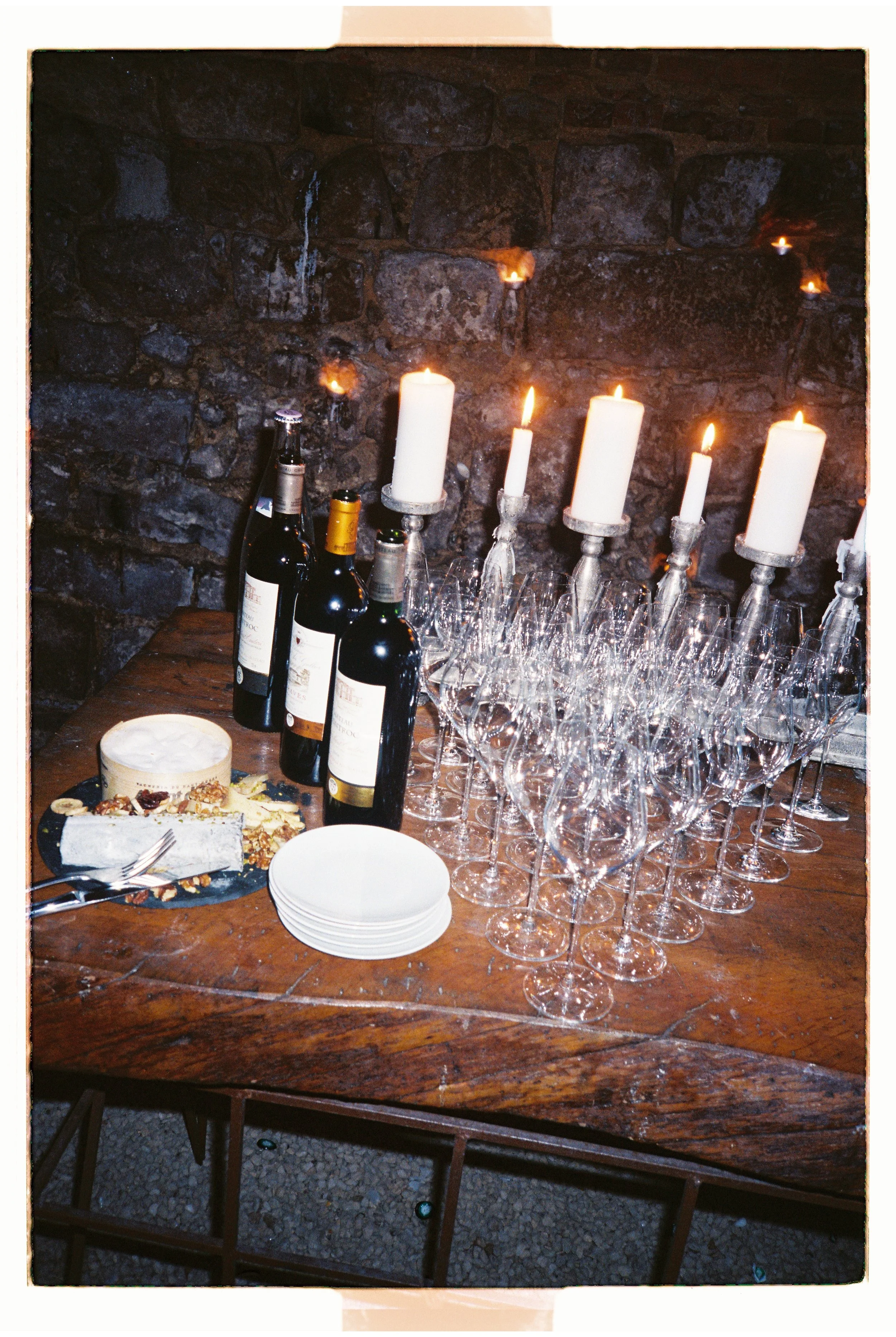 Elegant wedding reception table with candles, glassware and wine bottles in a refined atmosphere