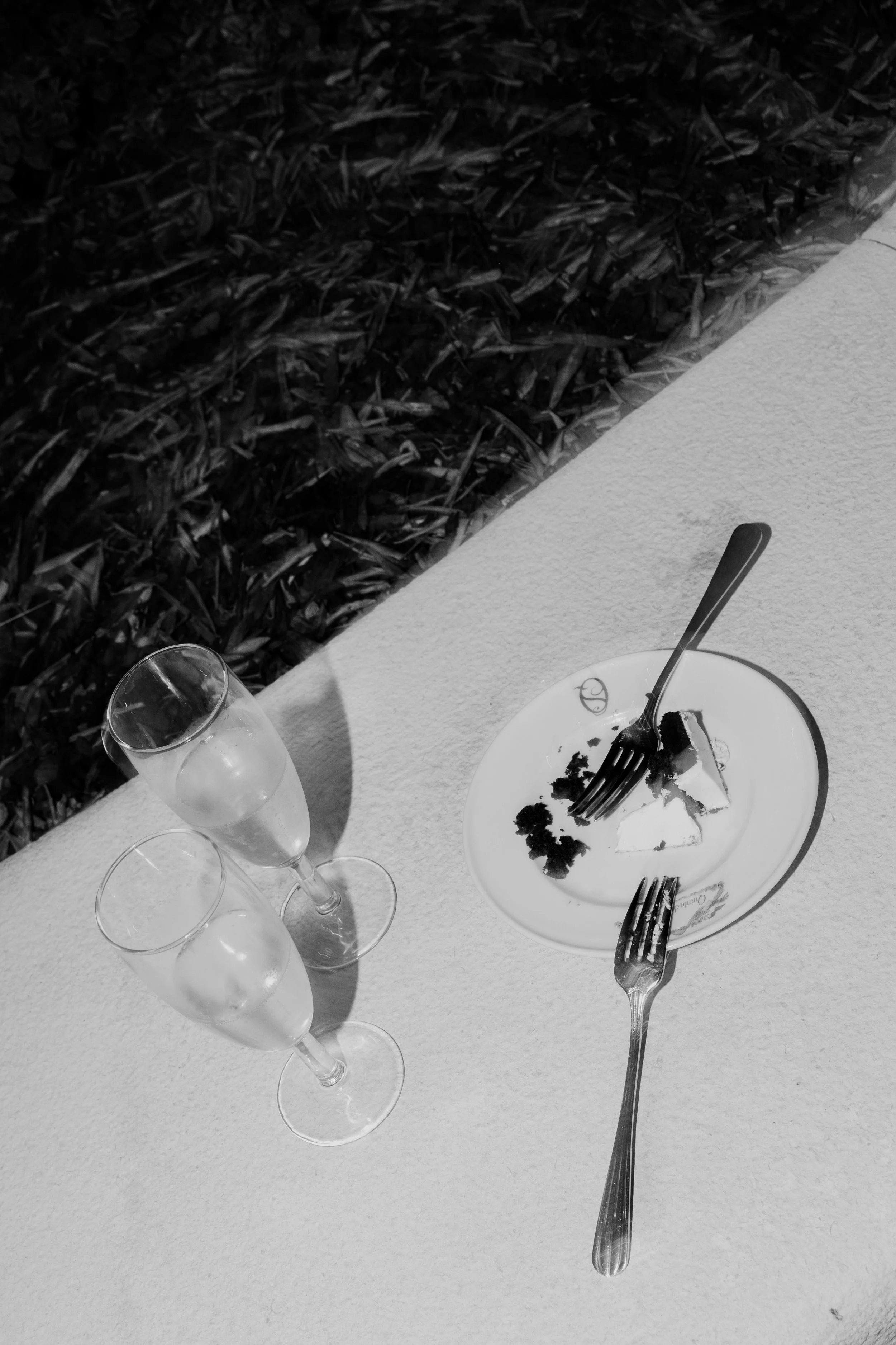 Artistic black and white composition of wedding table details with glassware and cutlery