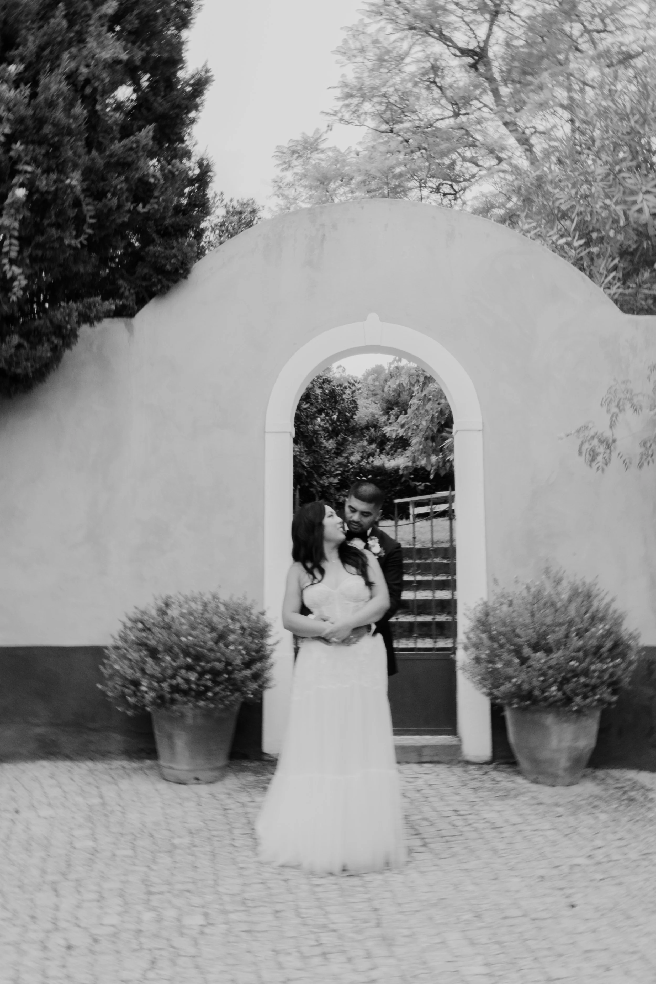 Bride standing under an archway during a romantic wedding in Portugal