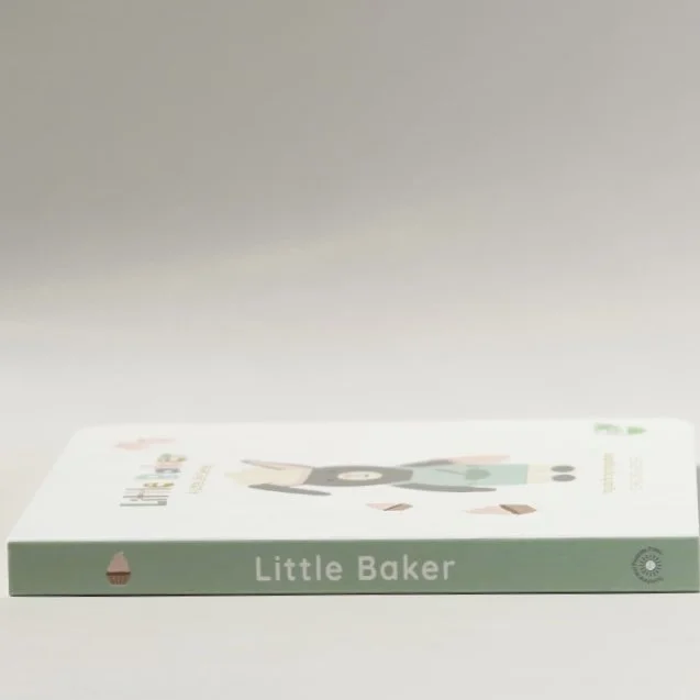 Book titled "Little Baker" with an illustration of a bear and a cake on the cover, lying flat on a white surface.