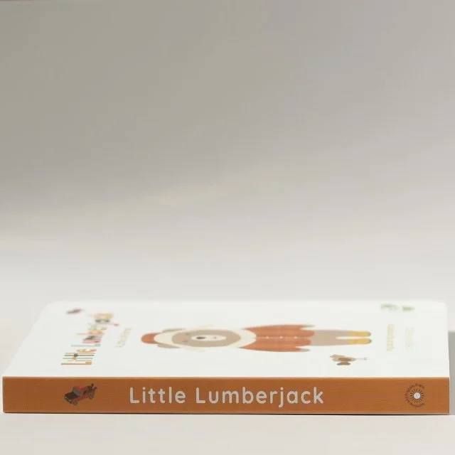 A children's book titled "Little Lumberjack" with a cartoon illustration of a bear wearing a red shirt on the cover, lying flat on a white surface.