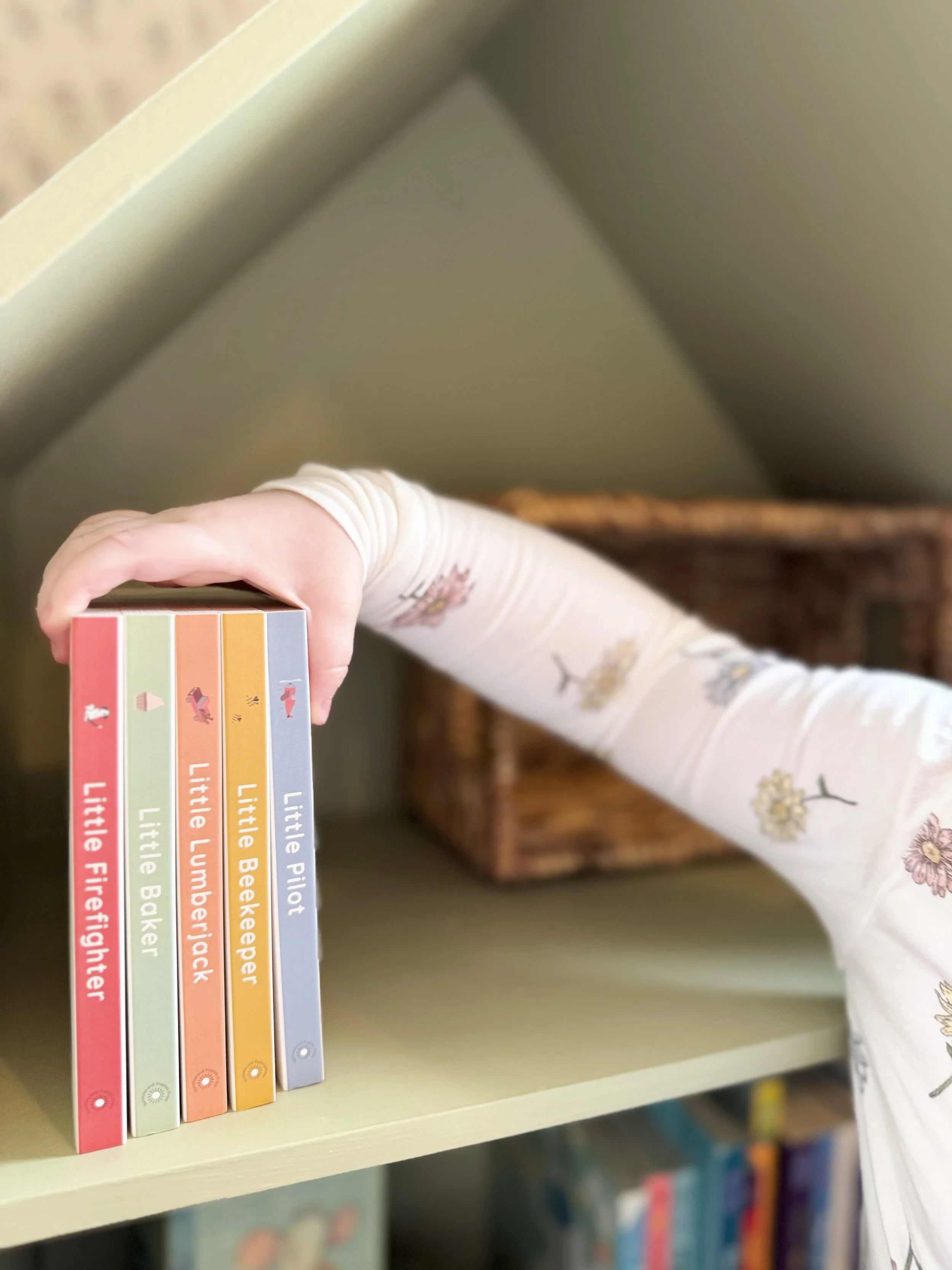 Stack of Sunshine & Poppies Press board books featuring Little Lumberjack, Little Beekeeper, and other career-themed titles