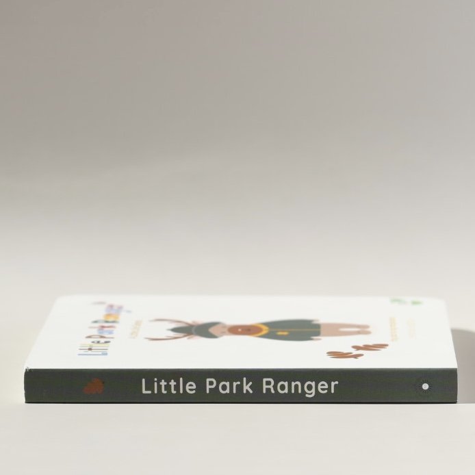 Side view of a children's book titled 'Little Park Ranger' with an illustration of a character in ranger gear on the cover, lying flat on a white surface.