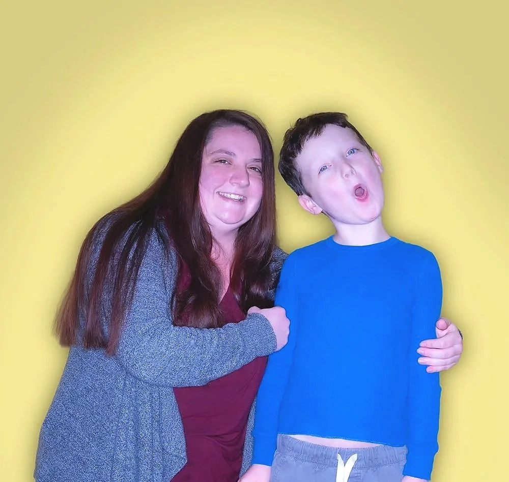 A woman with long brown hair smiling and a boy with blue eyes making a surprised face, standing against a yellow background.