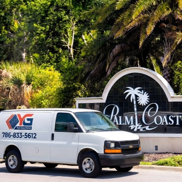White van parked in front of a Palm Coast sign with palm trees and lush greenery in the background.