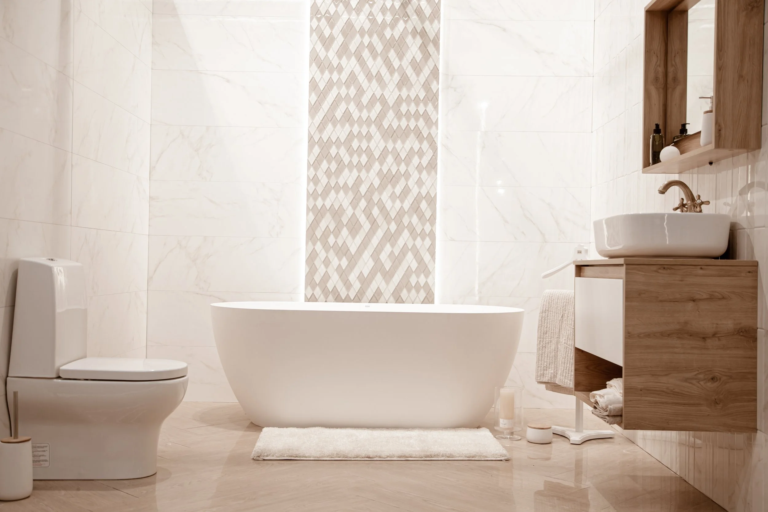 Modern bathroom with a white freestanding bathtub, toilet, wooden vanity with a vessel sink, and decorative wall tiles.