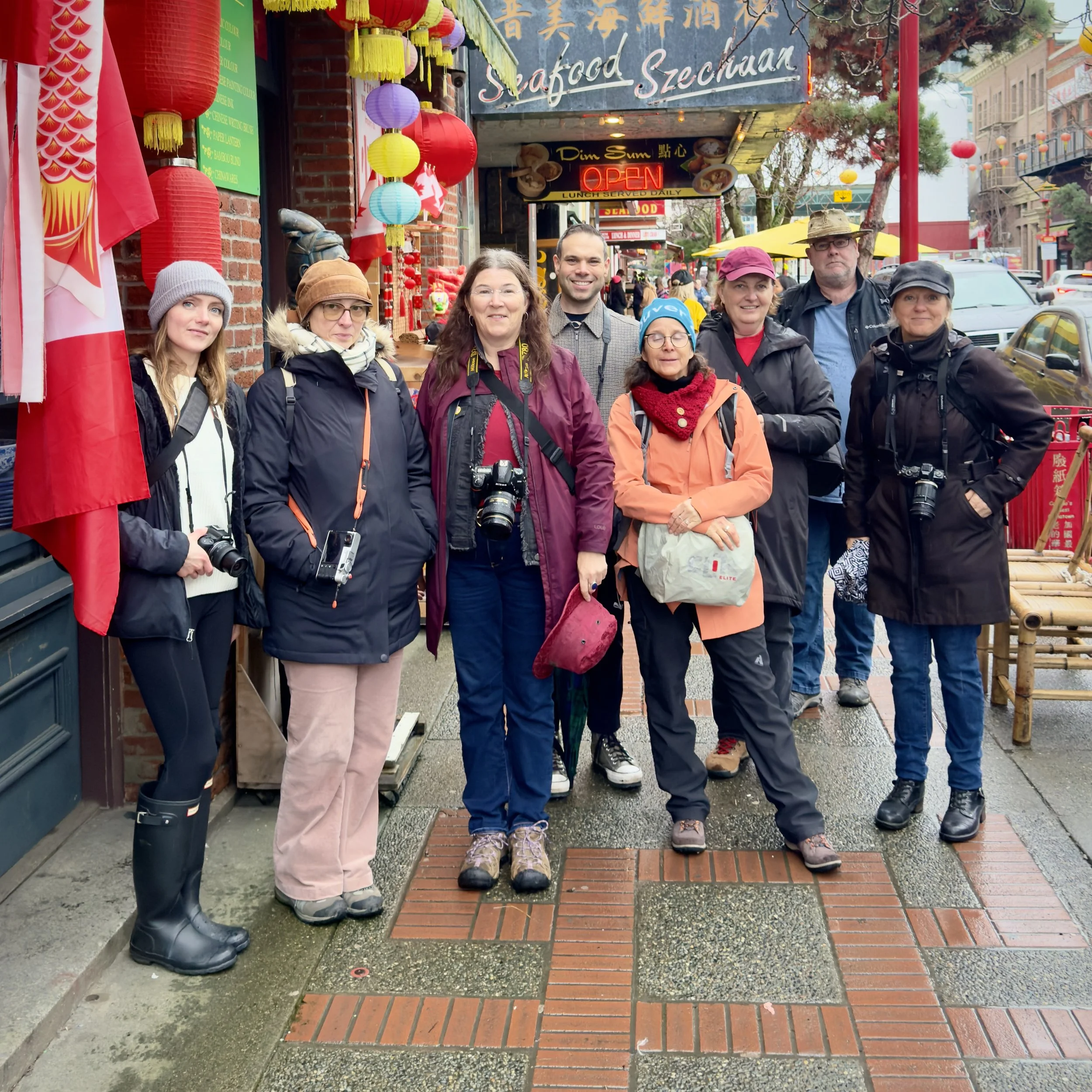 a group of photographers gather on the sidewalk in Chinatown