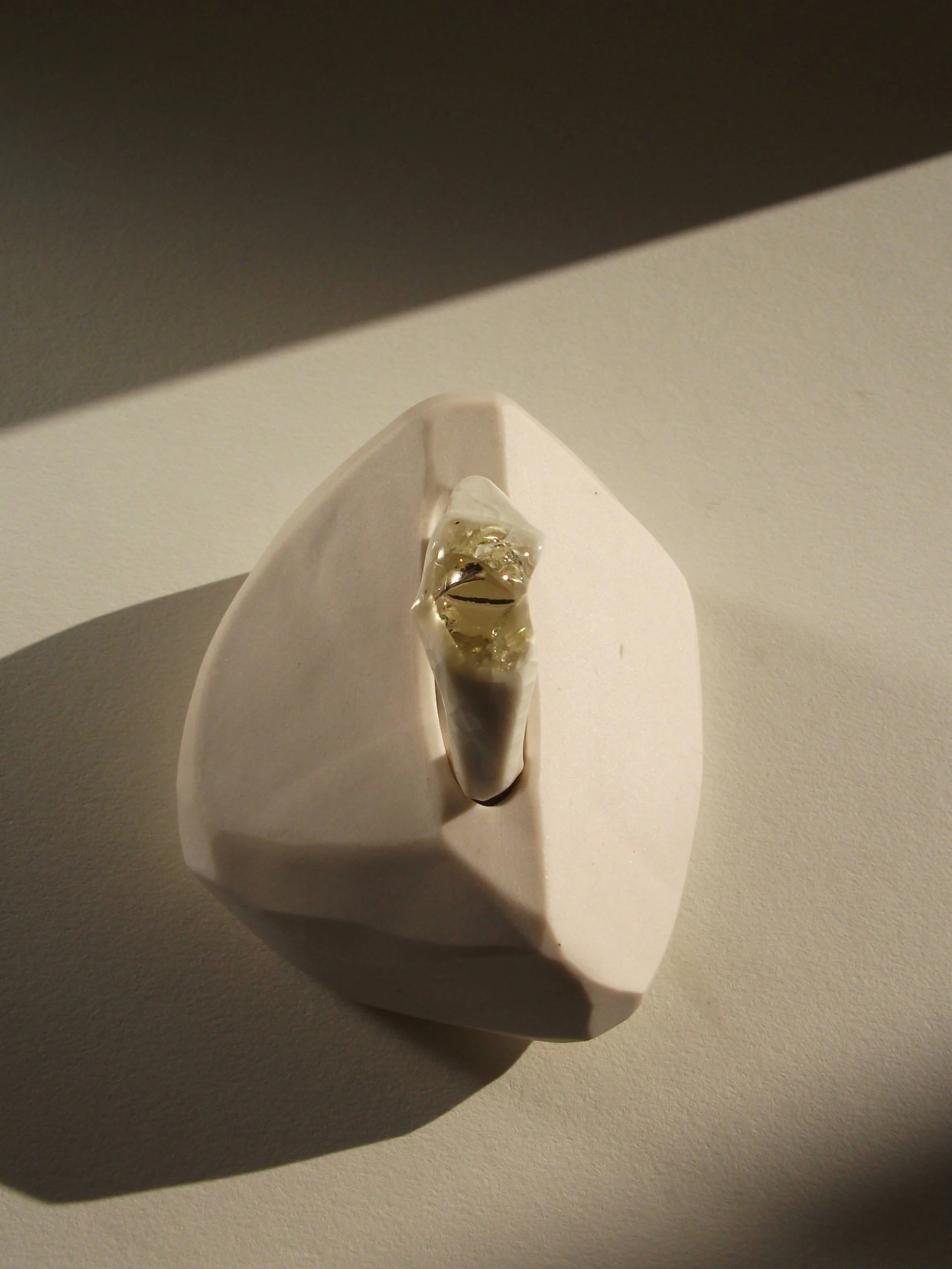 Top view of bone-white porcelain ring with crackle surface and soft champagne glass jewel