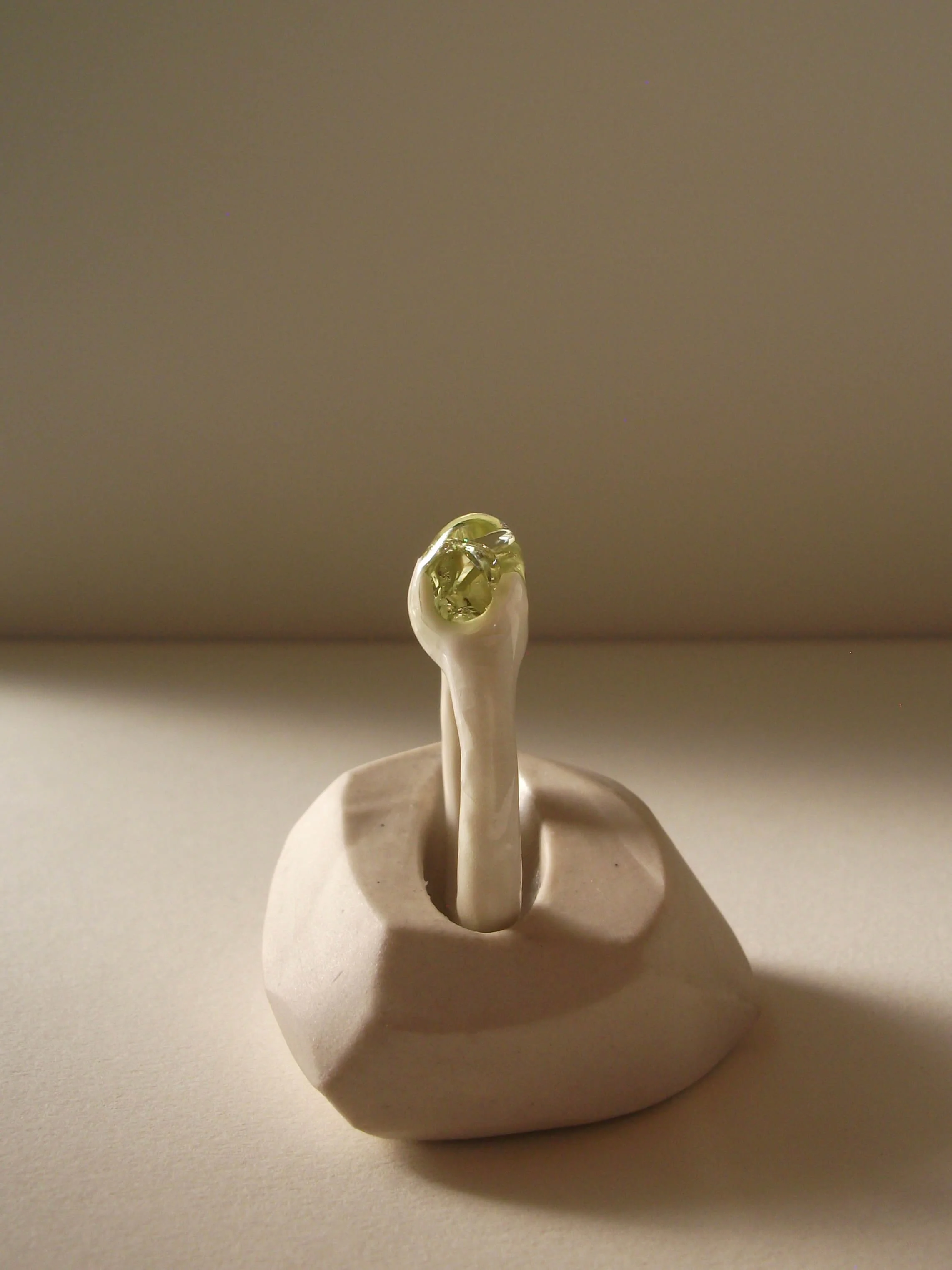 Side view of bone-white porcelain ring with thin band and crackle texture