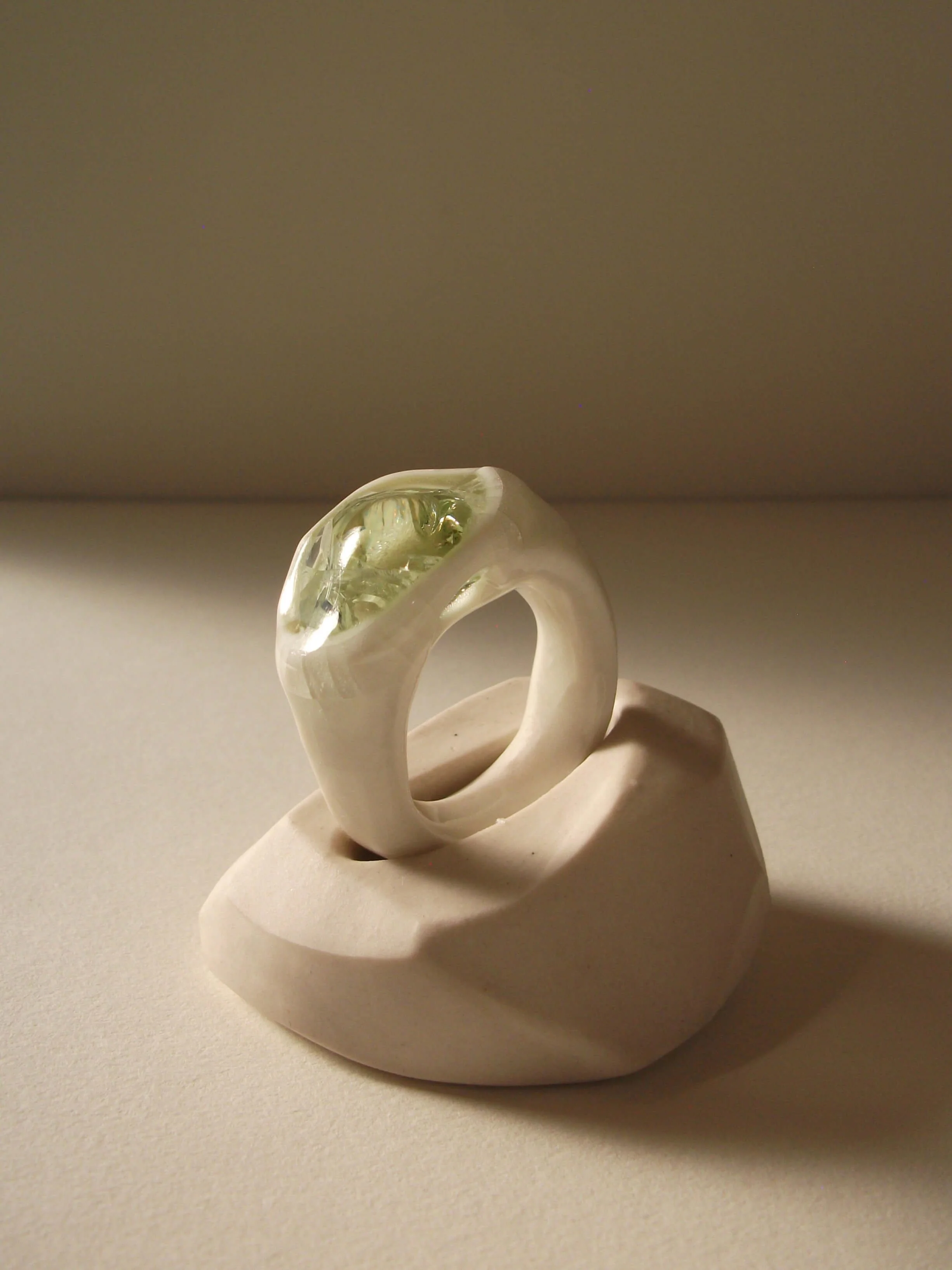 Side view of bone-white porcelain ring with thick band and crackle texture