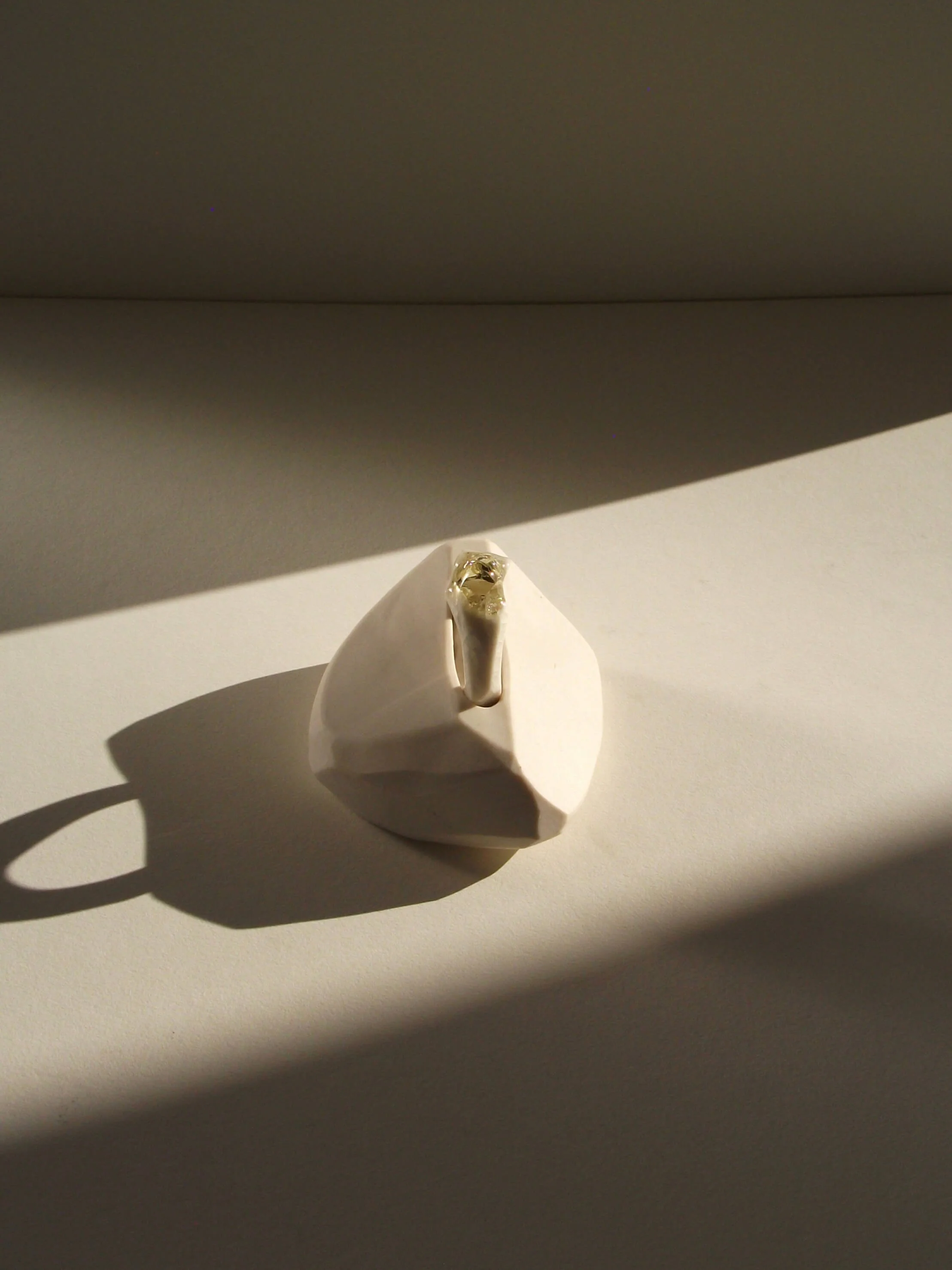 Top view of bone-white porcelain ring with crackle surface and soft champagne glass jewel