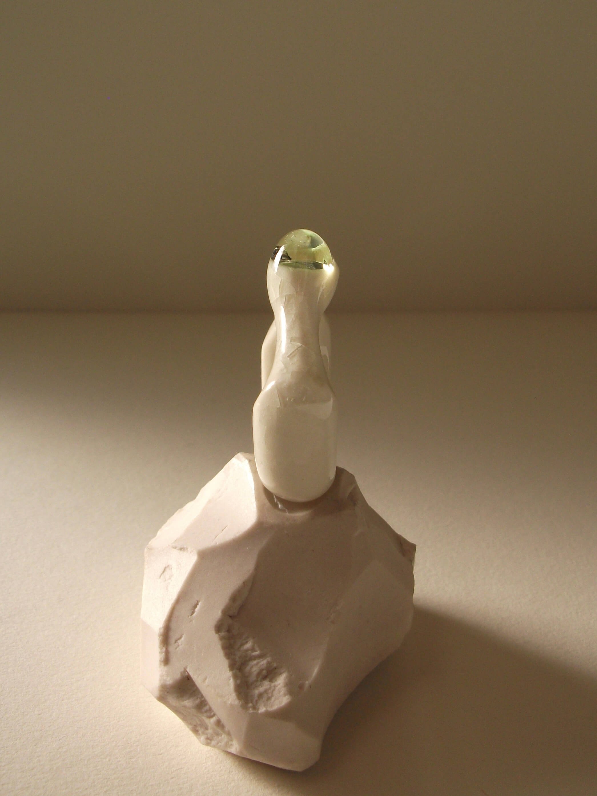 Side view of bone-white porcelain ring with thick architectural band and light celadon glass droplet