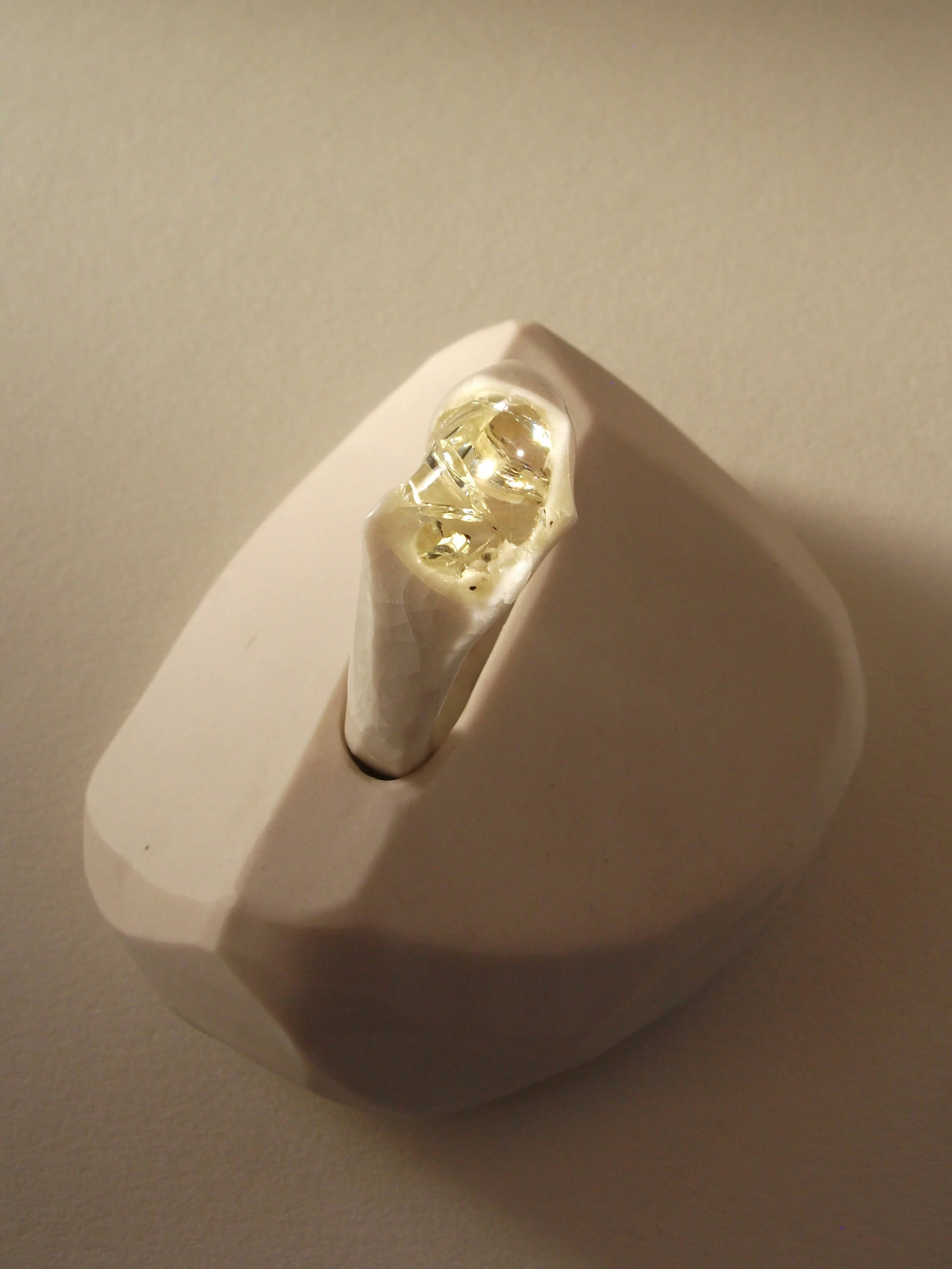 Top view of bone-white porcelain ring with crackle surface and soft champagne glass jewel, close-up