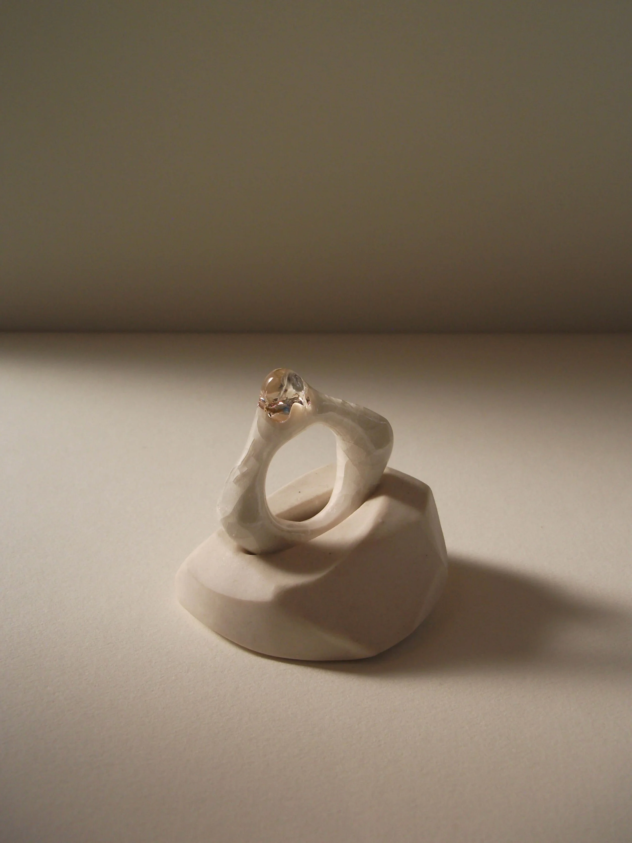 Side view of bone-white porcelain ring with crackle texture