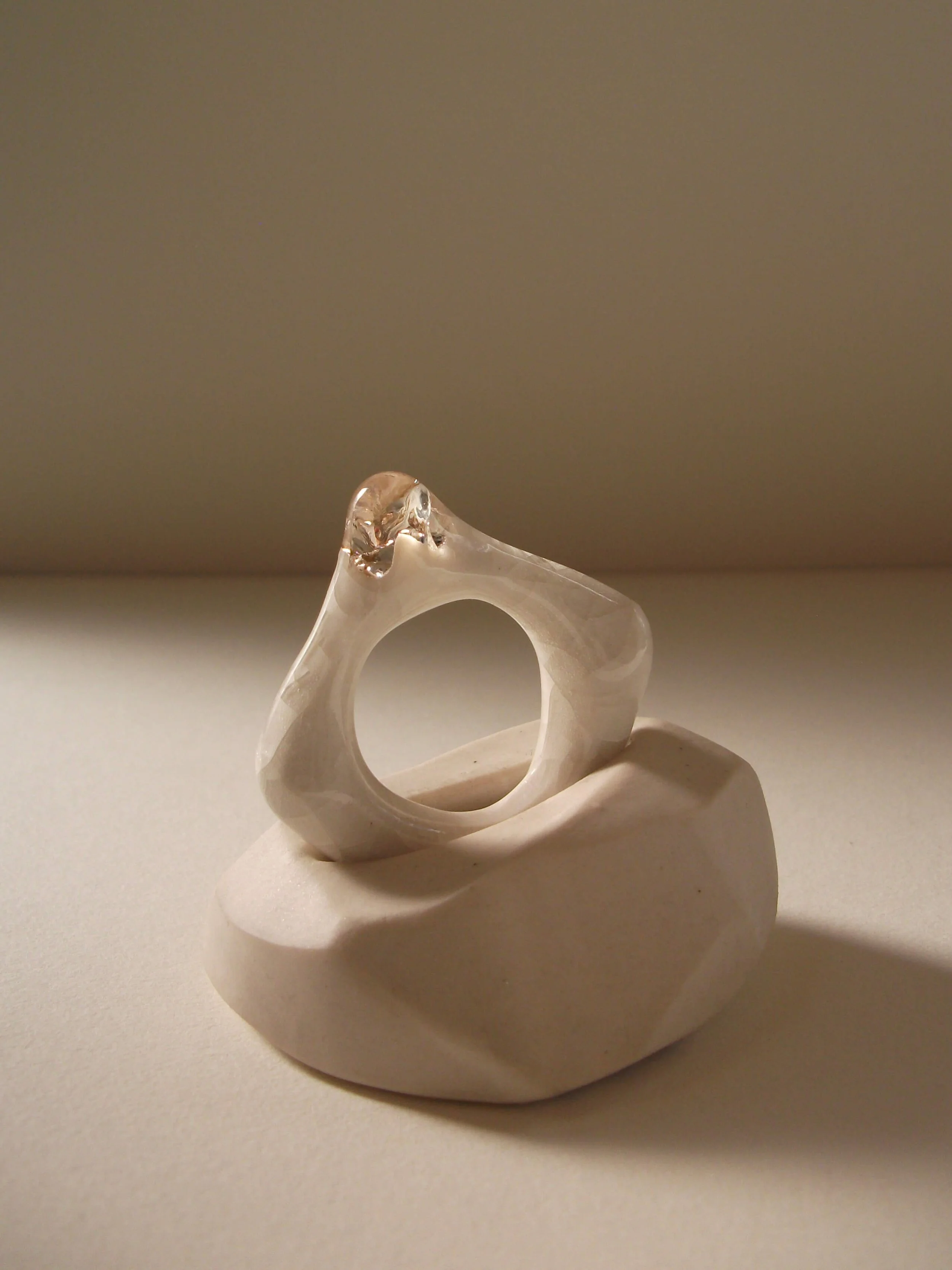 Side view of bone-white porcelain ring with crackle texture