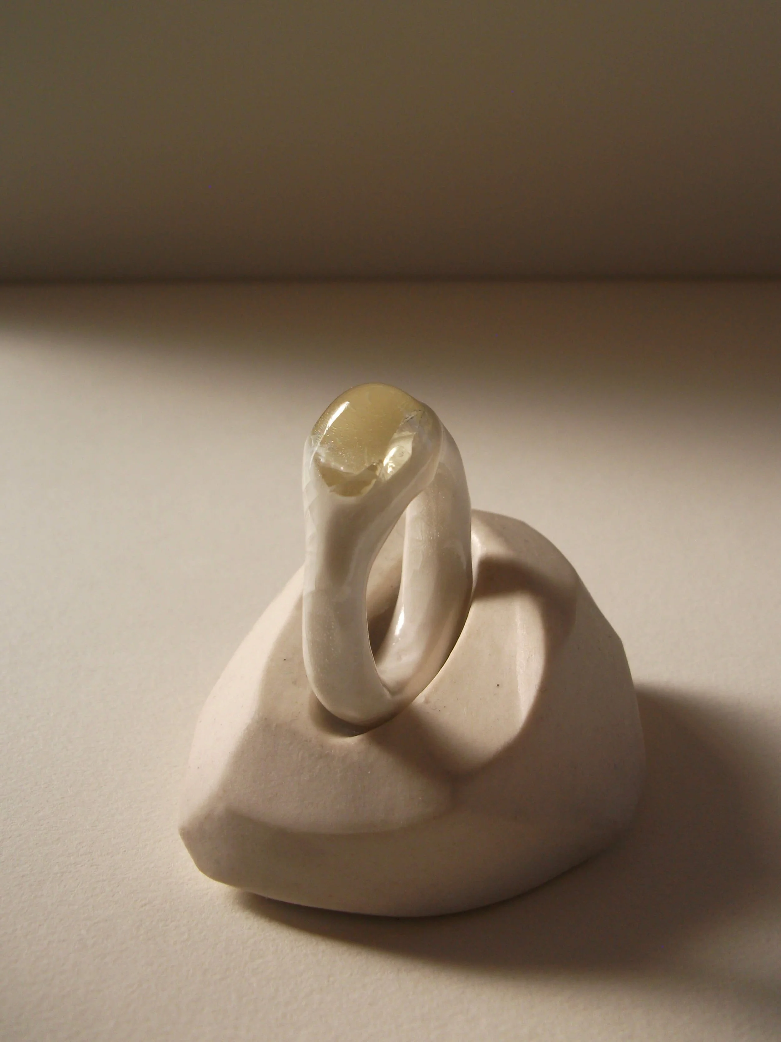 Bone-white porcelain ring with crackle surface and central glass jewel