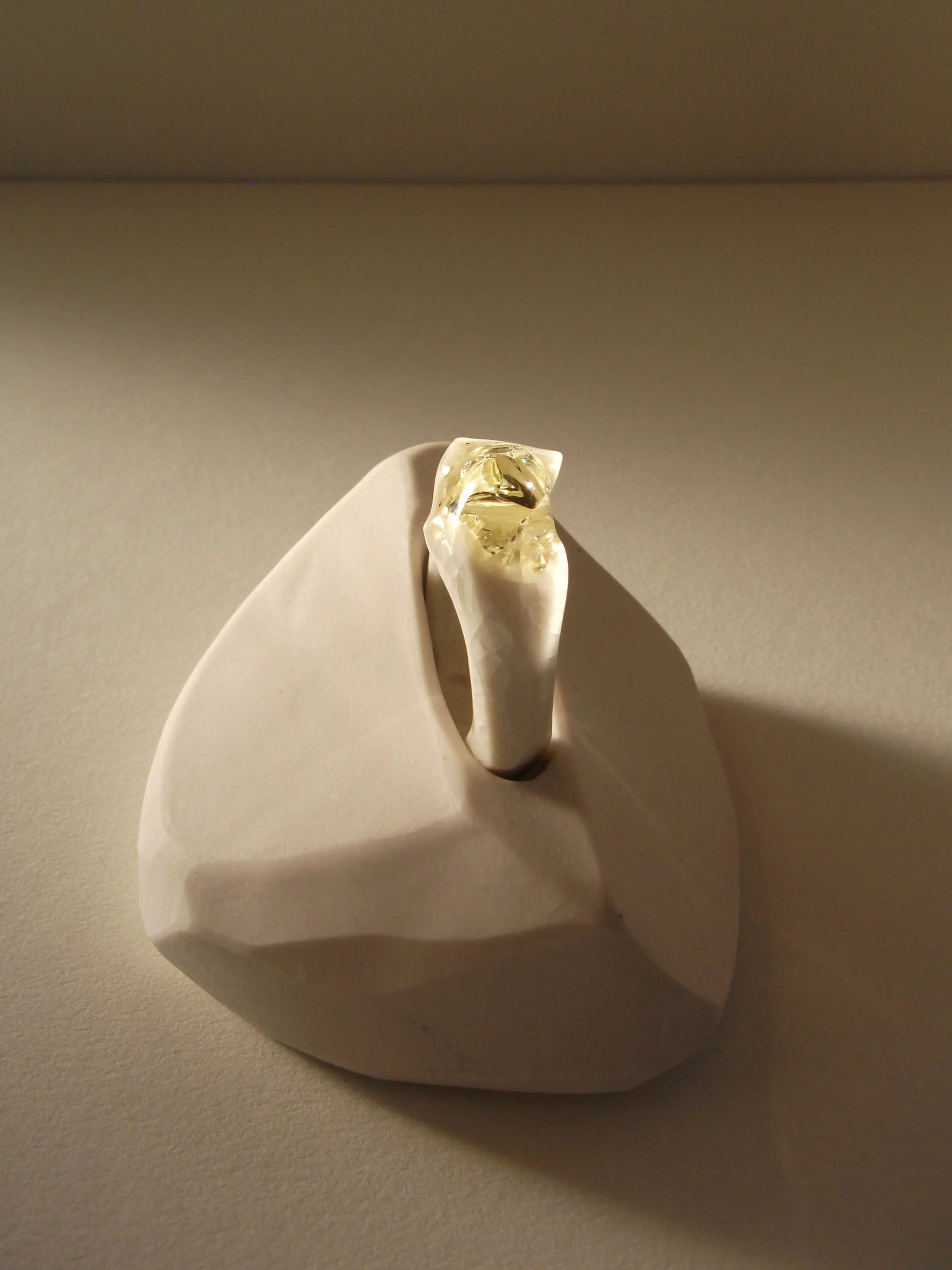 Top view of bone-white porcelain ring with crackle surface and soft champagne glass jewel