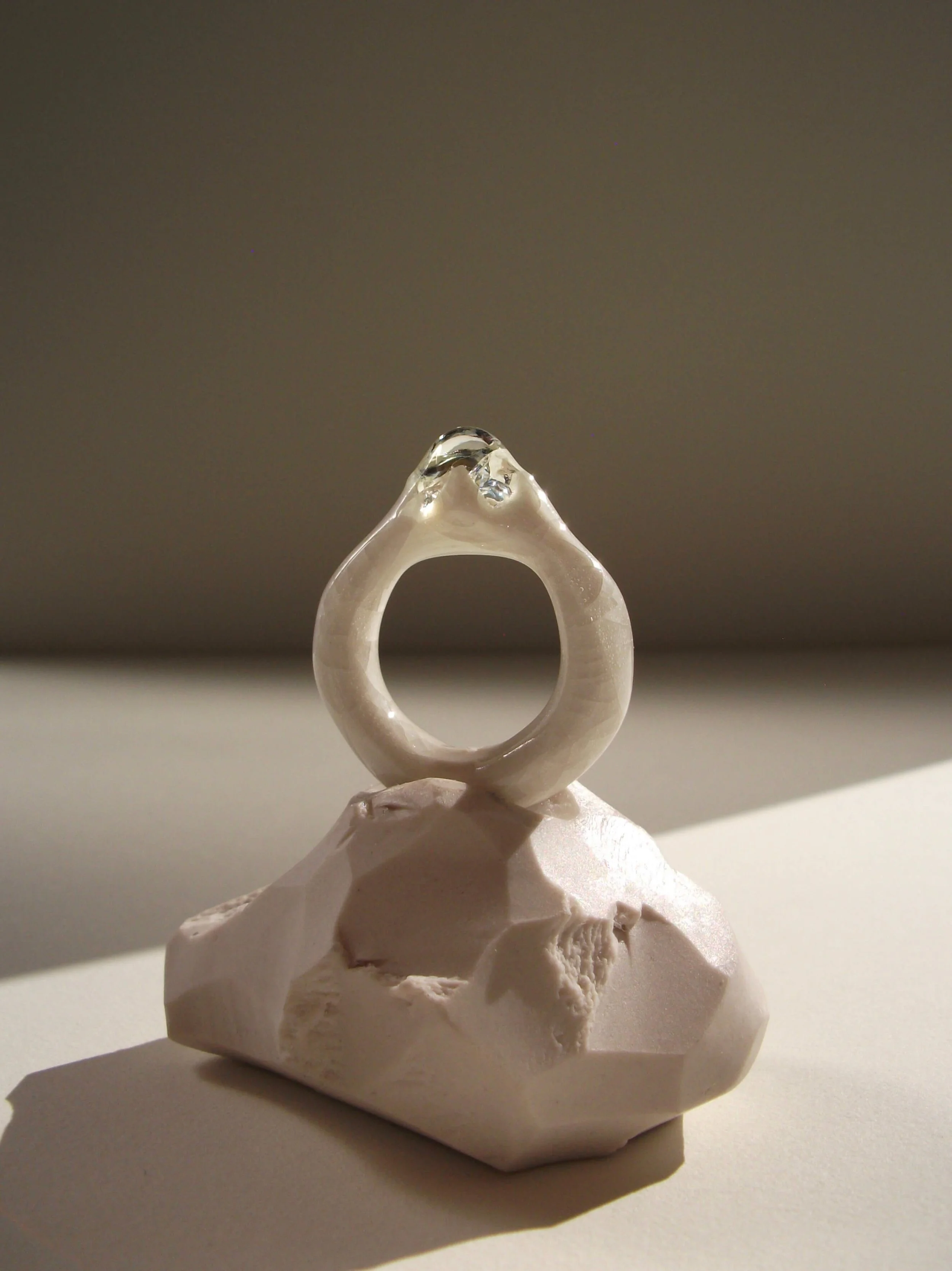 Bone-white porcelain ring with medium-wide band, crackle surface, and large glass droplet