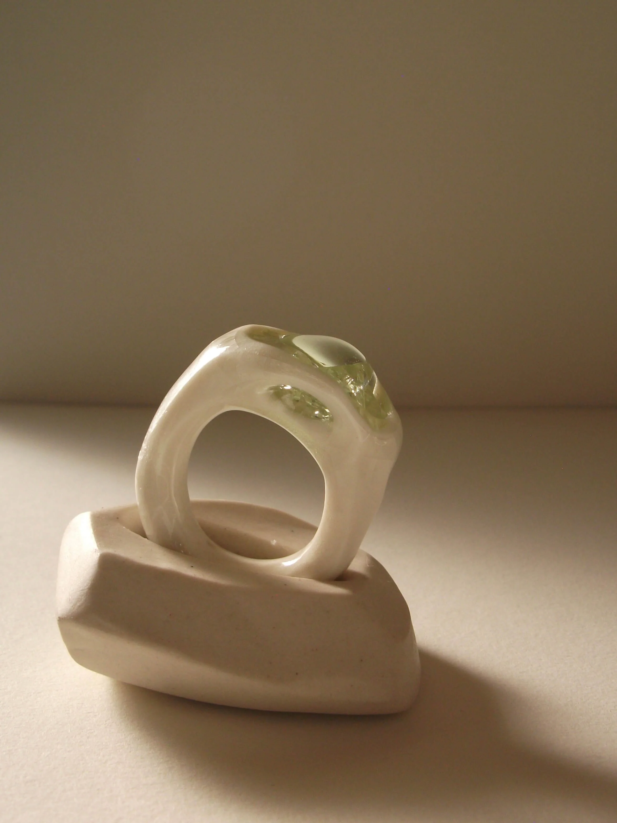 Side view of bone-white porcelain ring with thick band and crackle texture