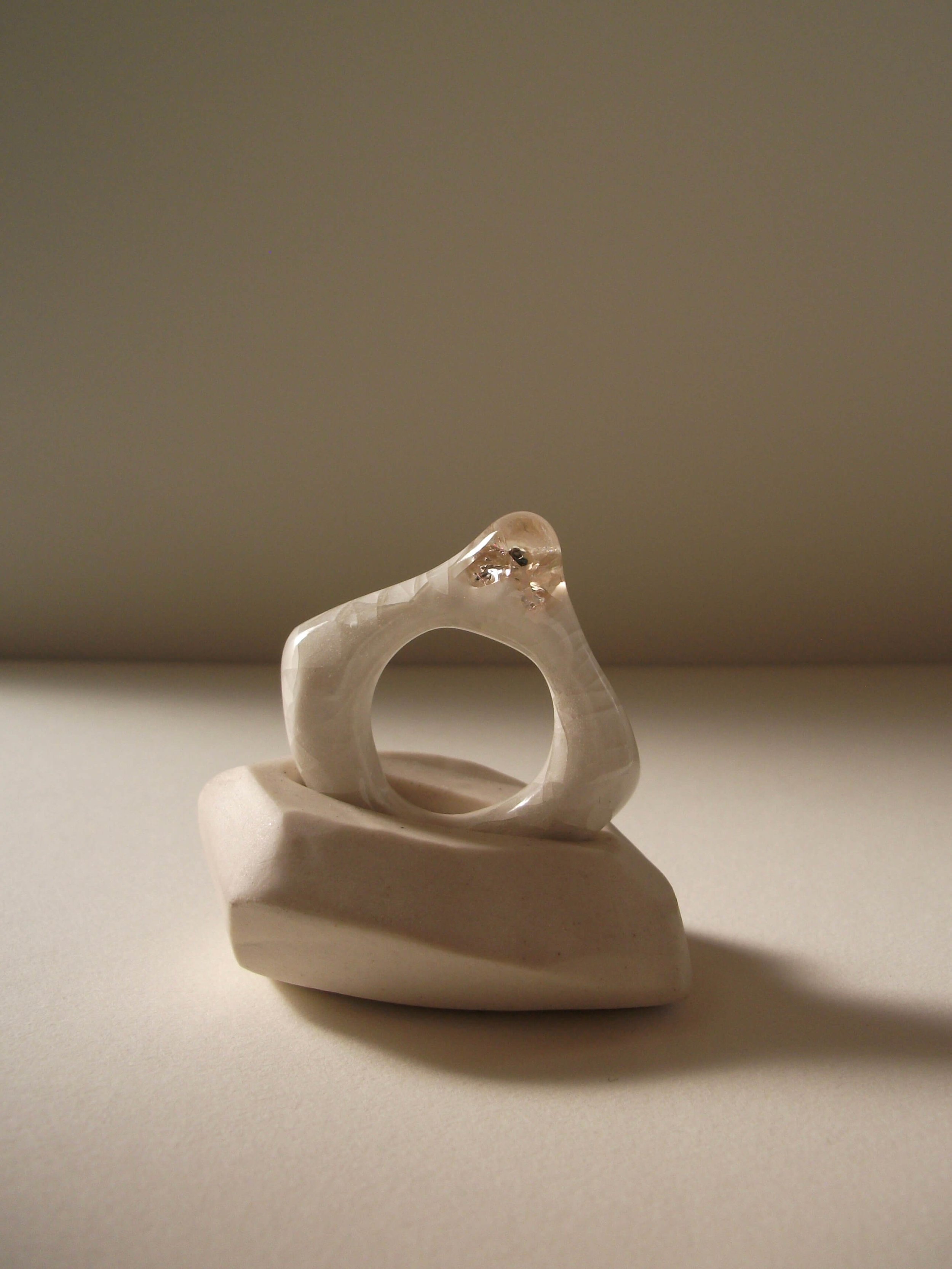 Side view of bone-white porcelain ring with crackle texture