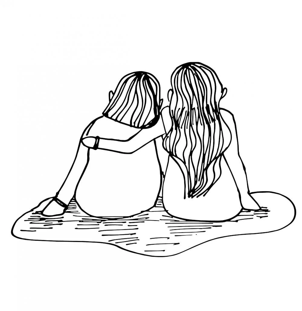 Two girls with long hair sitting on a blanket, hugging and talking to each other.