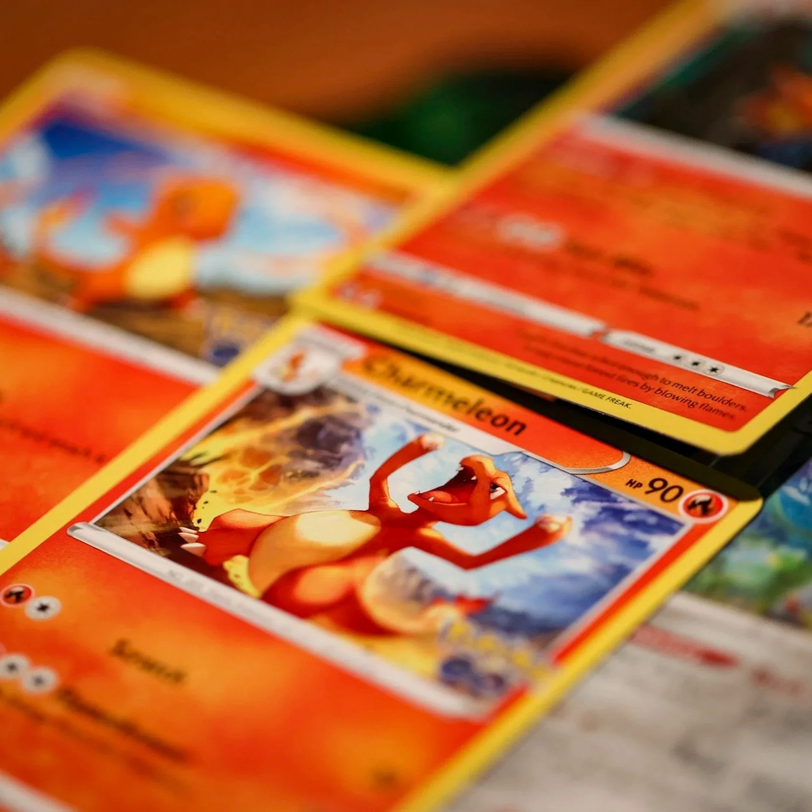 Collection of Pokémon cards, with one featuring Arcanine prominently in the center, set against a fiery background.