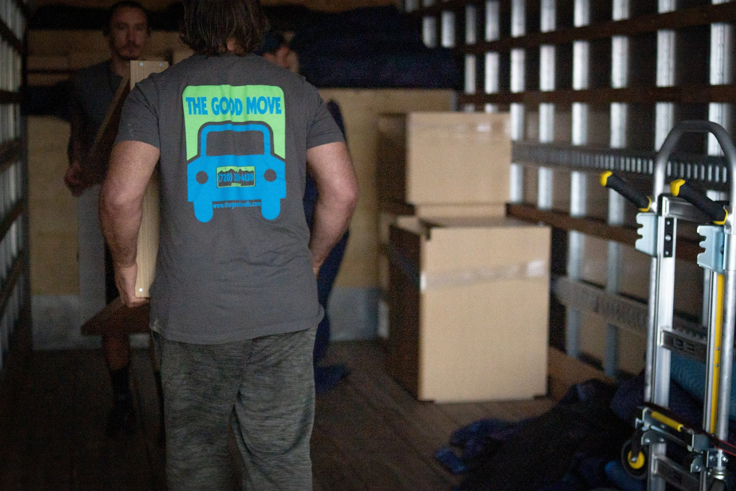 Happy customer celebrating a successful move surrounded by boxes — stress-free moving with The Good Move, Colorado movers.