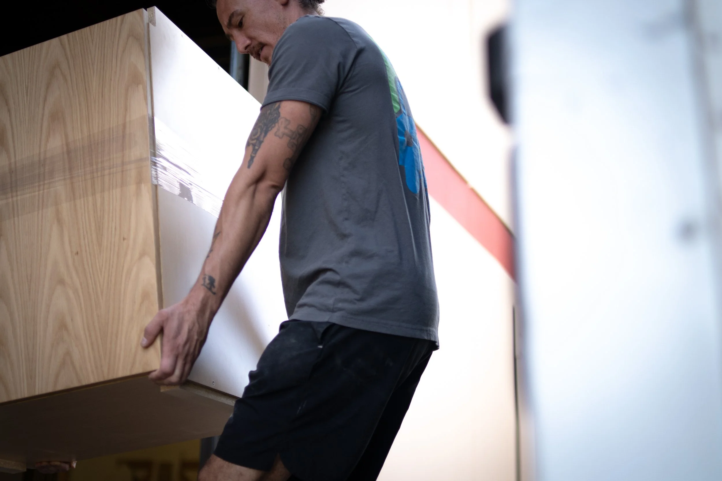 The Good Move mover lifting a sofa with boxes ready for relocation — Boulder & Denver moving help.