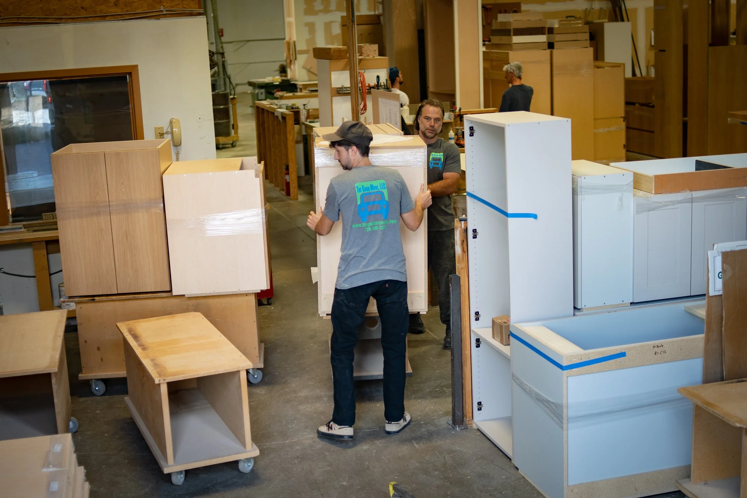The Good Move team moving a heavy kitchen cabinet with proper lifting technique