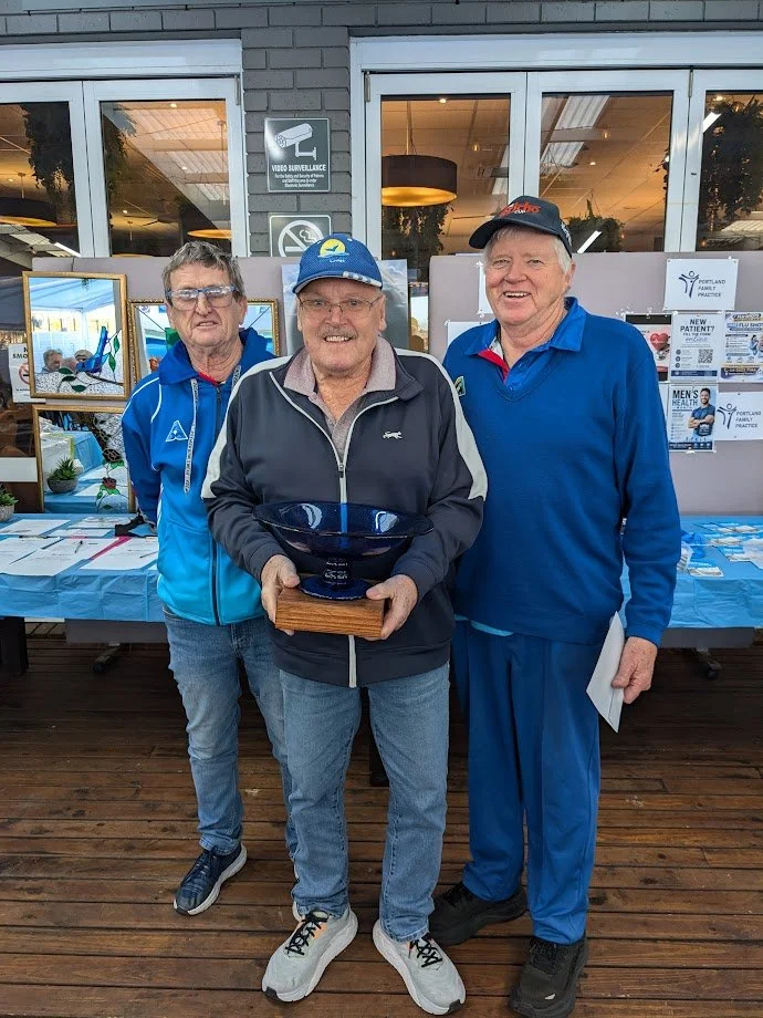 3 men holding a trophy