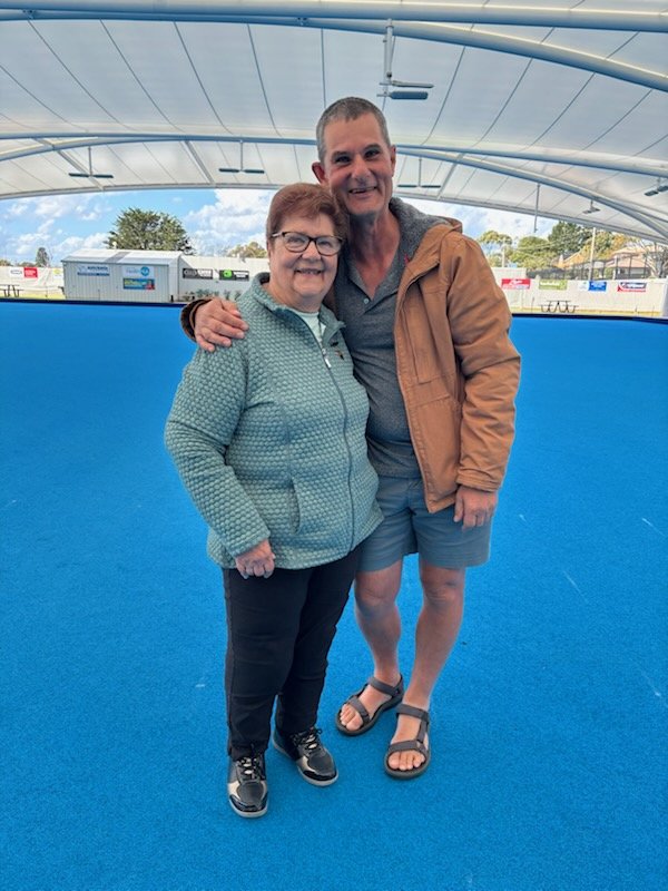 a man and woman on a blue bowling surface
